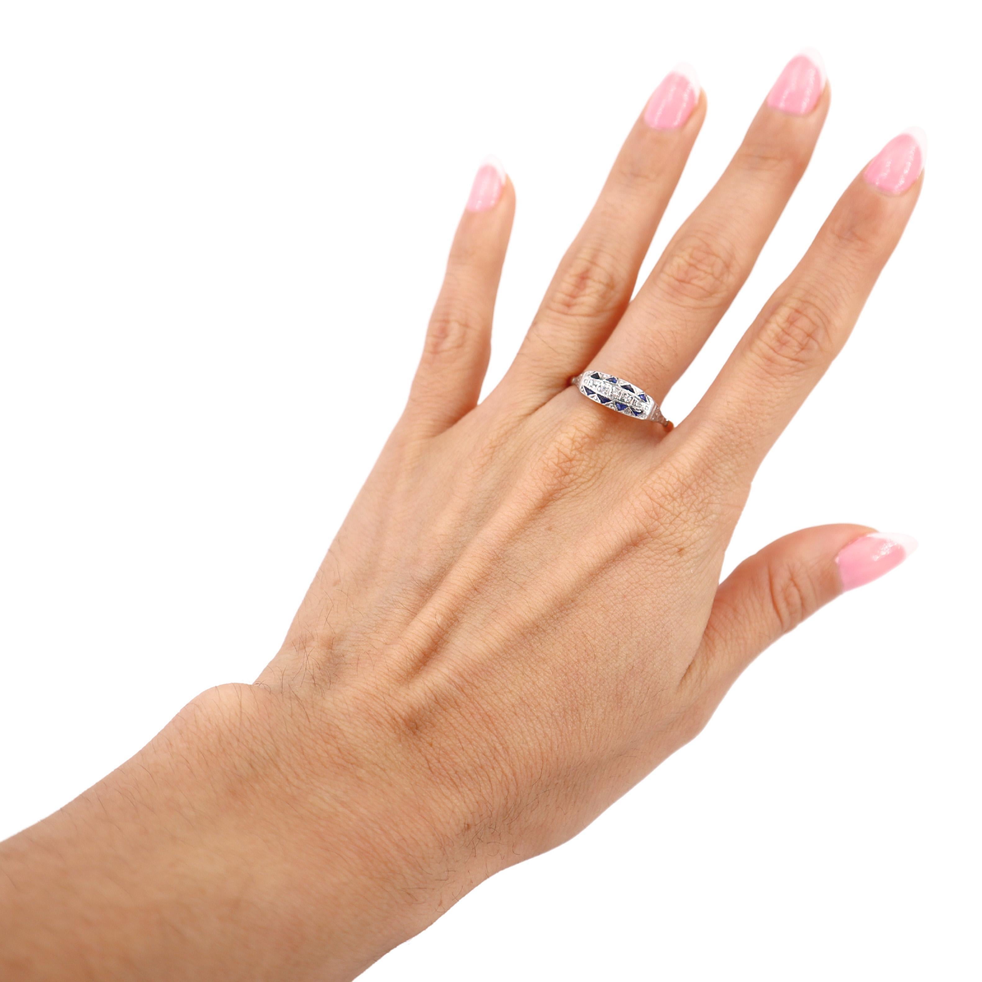 This stunning Art Deco ring, dating back to the 1920s, is a beautifully crafted piece made from 18kt yellow gold with a platinum top. Its intricate design is enhanced by a milgrain finish, a hallmark of Art Deco jewelry. The centerpiece