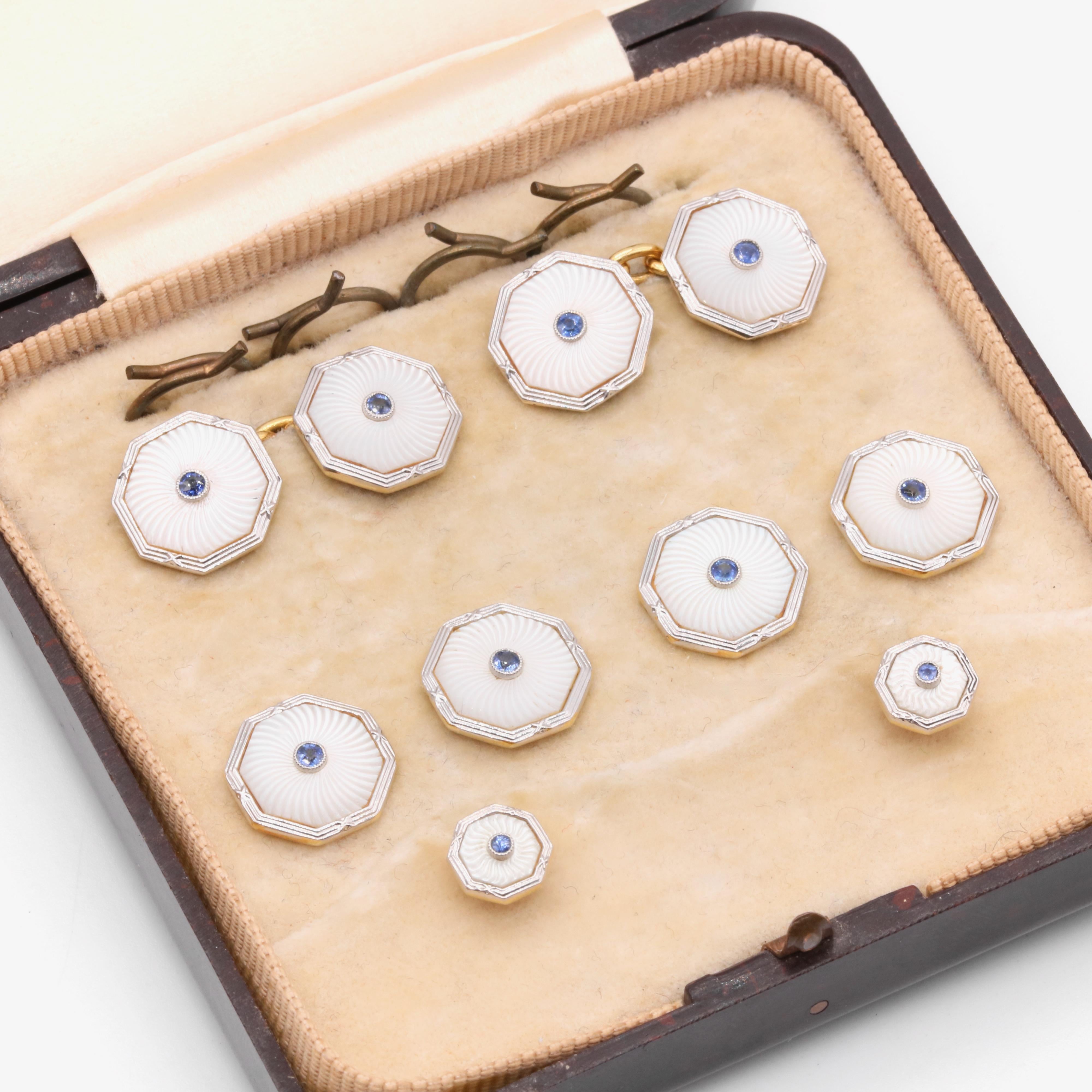 A set of Art Deco sapphire, mother of pearl, platinum, and yellow gold cufflinks and dress buttons, each comprising one round cut blue sapphire, and a carved panel of mother of pearl, platinum, an 18 karat yellow gold. 

This glamorous gentleman’s