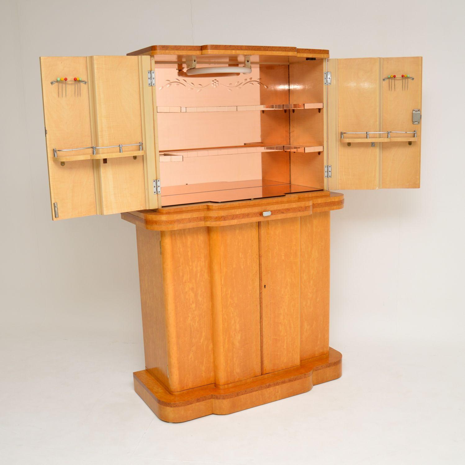 An absolutely stunning and top quality original Art Deco cocktail cabinet, made by Epstein in the 1920s-1930s. This has a gorgeous design and has many fine features.

This is predominantly made from lovely burr maple, with burr walnut trim. We