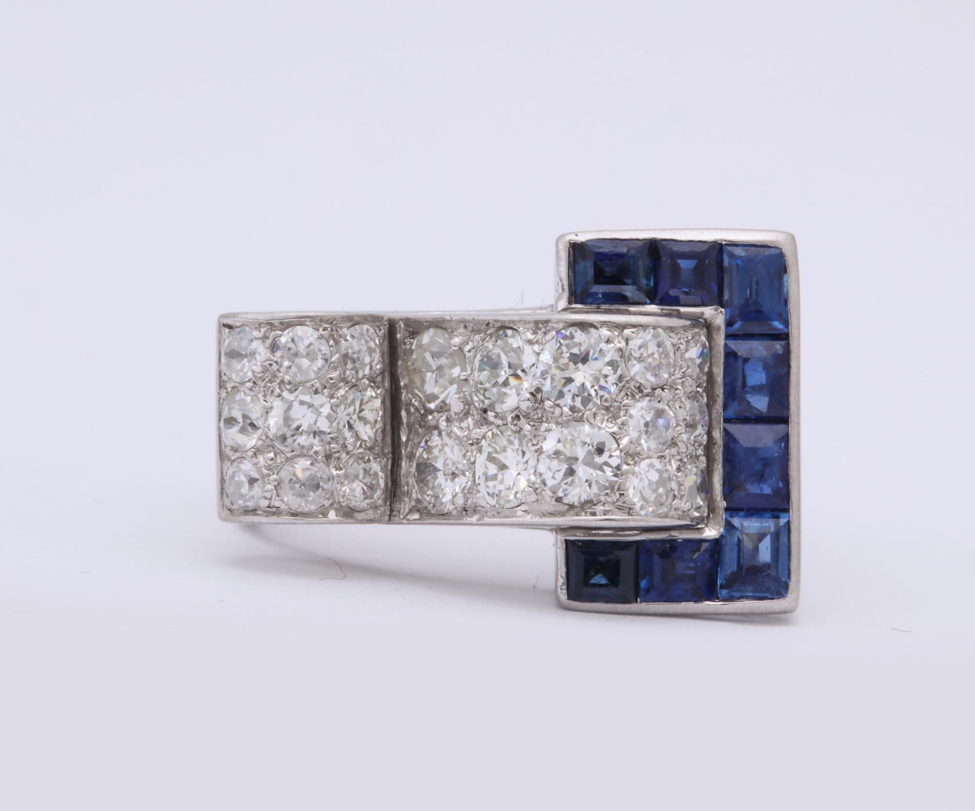 One Ladies High Style Buckle Design Platinum Ring Embellished With Eight Custom Cut Beautiful Color Calibre Cut Sapphires Weighing Approximately .75 Cts. This Geometric Ring Is Also Embellished With Numerous Old Cut Antique Cut Diamonds Weighing