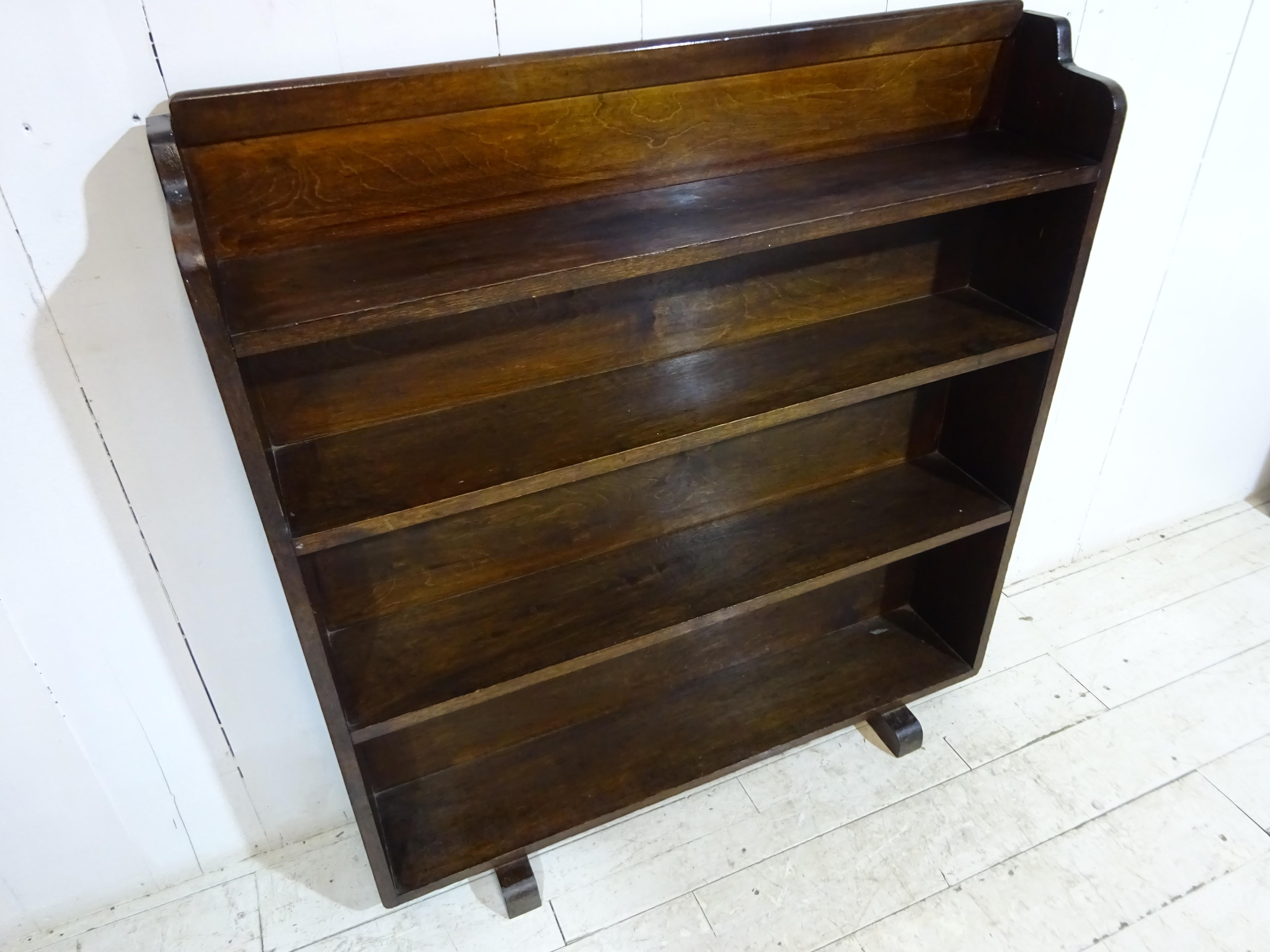 A lovely simple piece originally used for storing books and paperwork in a church office. Finished in solid oak the piece has a slightly distressed look and an aged patina. The design is typically art deco with a shaped and curved top and classic