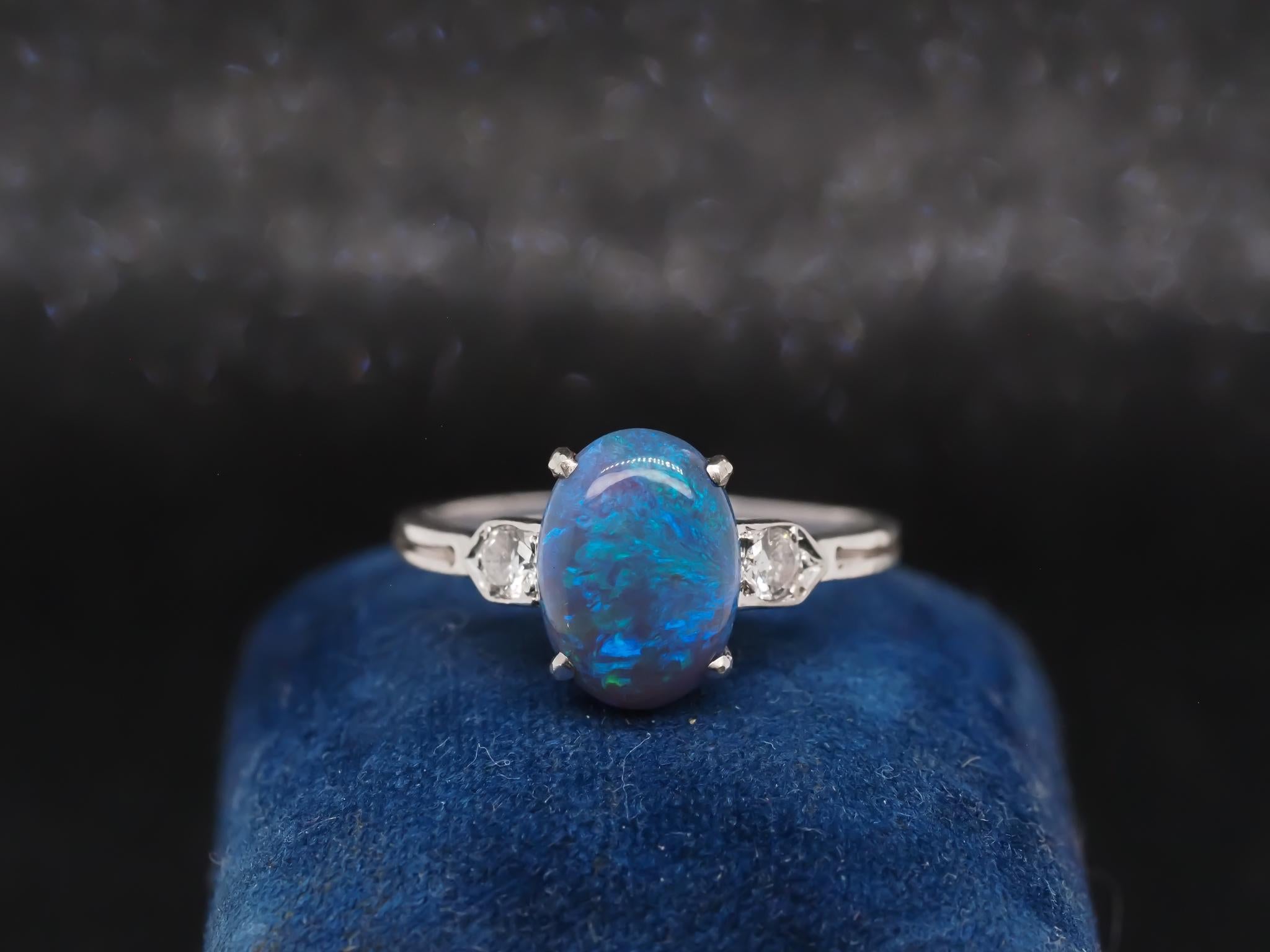 Year: 1920s

Item Details:
Ring Size: 10 (Sizable)
Metal Type: Platinum [Hallmarked, and Tested]
Weight: 3.4 grams

Diamond Details: Old European Brilliant, .25ct total weight, G Color, VS Clarity.

Opal Details: Black Opal, Natural, 11.5mm x 8.5mm,