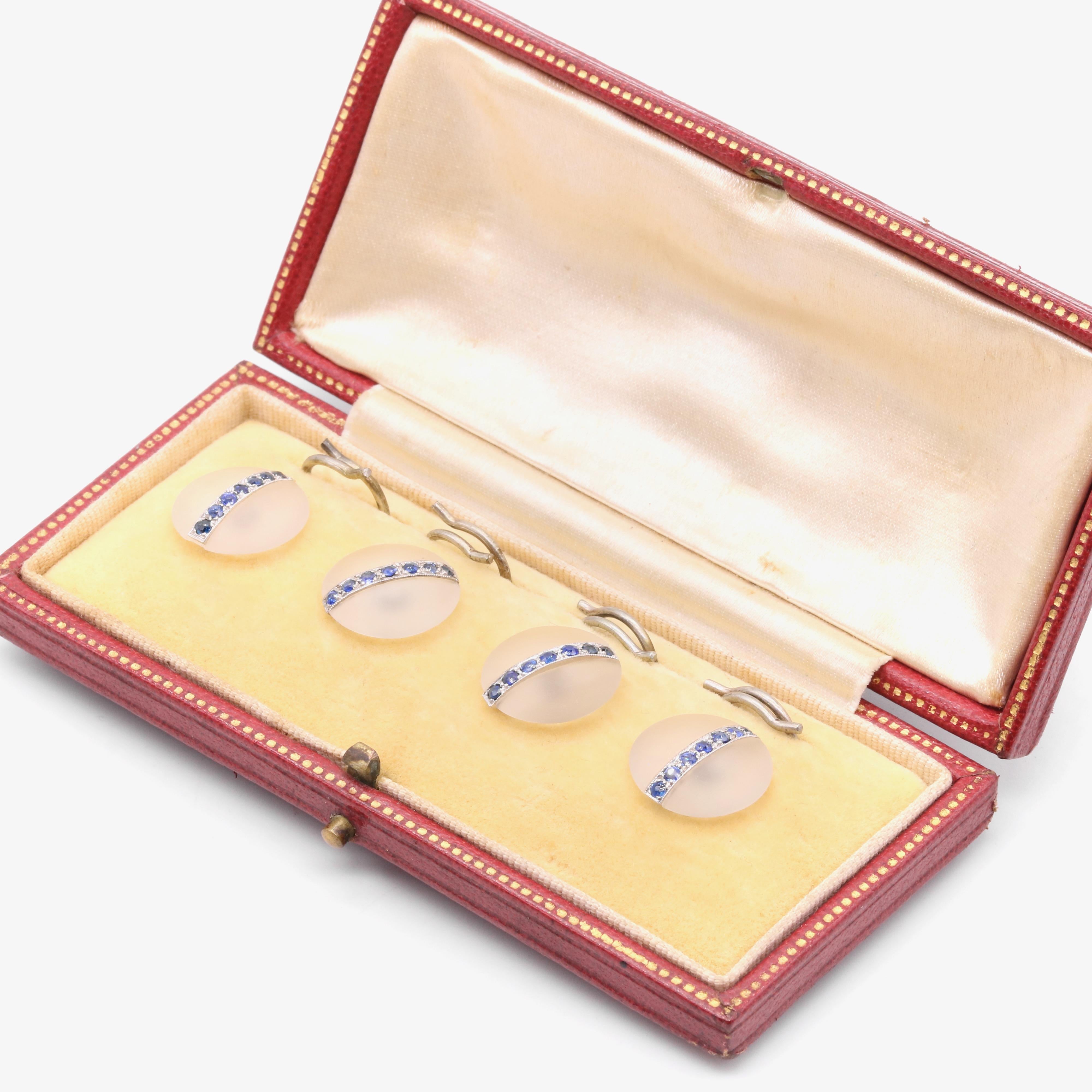 A set of four sapphire, rock crystal, and platinum dress studs, each comprising one round cabochon of frosted rock crystal, and seven sapphires, set in platinum, with platinum backs. 

The dress studs are beautifully designed, creating a real