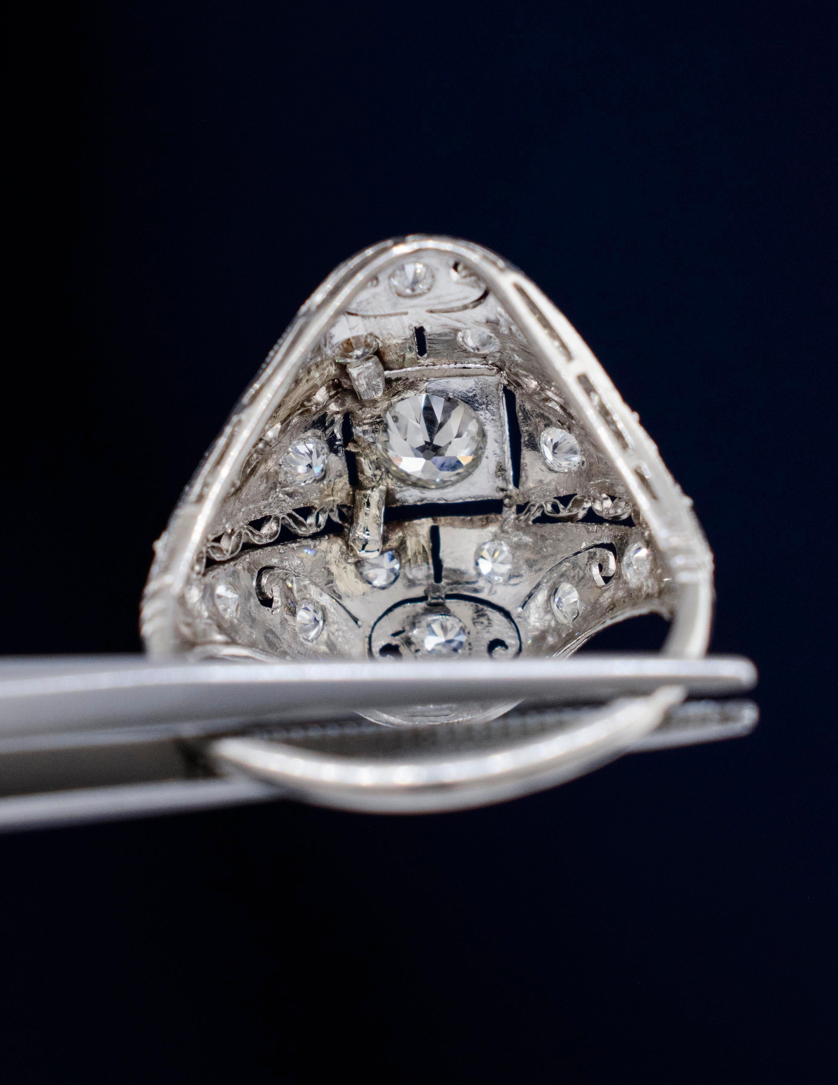 Un anello a cupola in platino Art Deco con diamante degli anni '20. Questo è un eccellente esempio di anello d'epoca in platino fatto a mano con incisioni a mano, lavorazione in filigrana e bordi in graniglia. 
Al centro è incastonato un diamante di