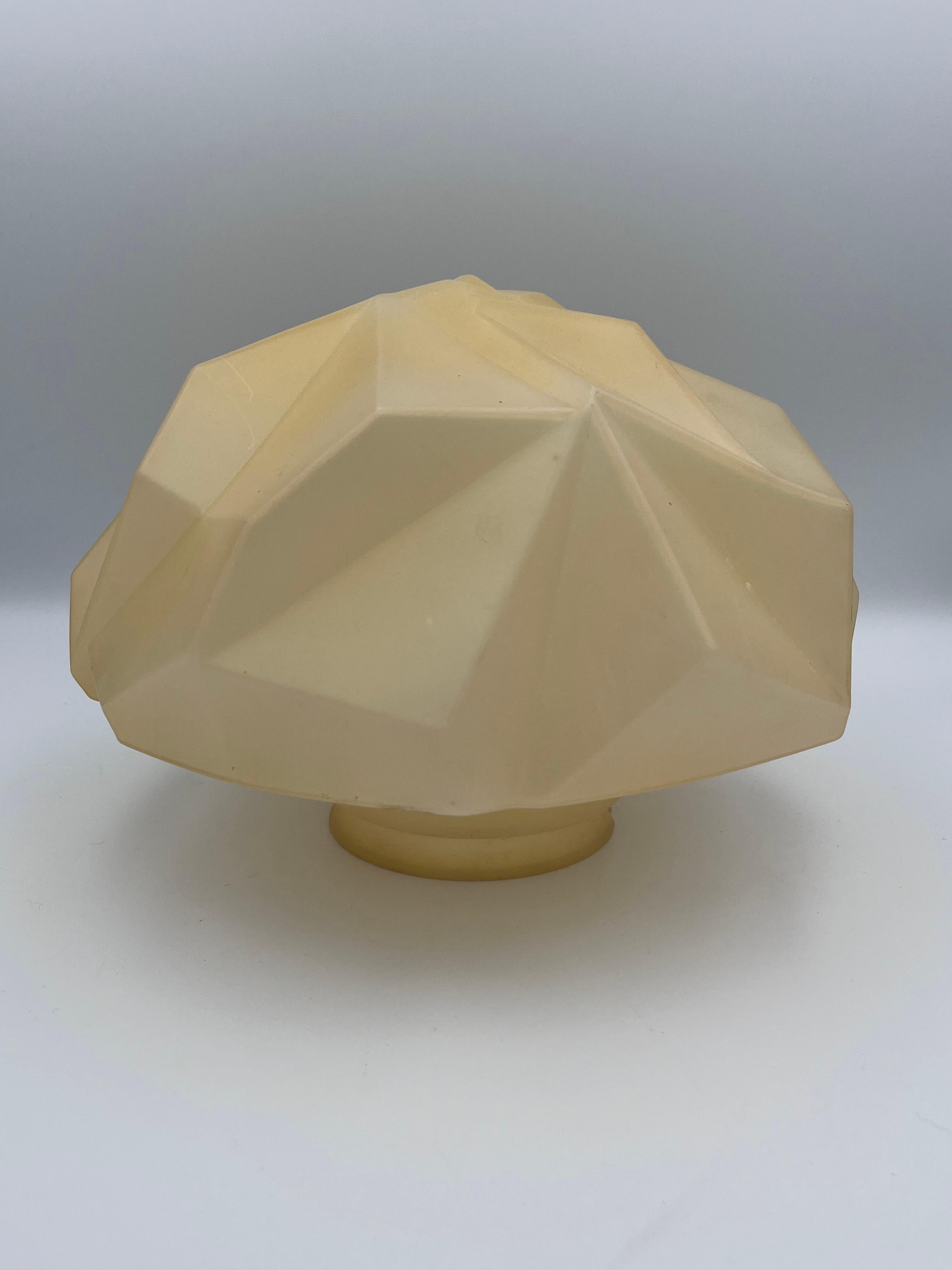 This rare 1920s Ruba Rombic flush mount glass shade, designed by Reuben Haley for the Consolidated Glass Company, exemplifies the sharp, angular cubist motifs that defined Art Deco design. Molded in etched beige glass with striking geometric relief,