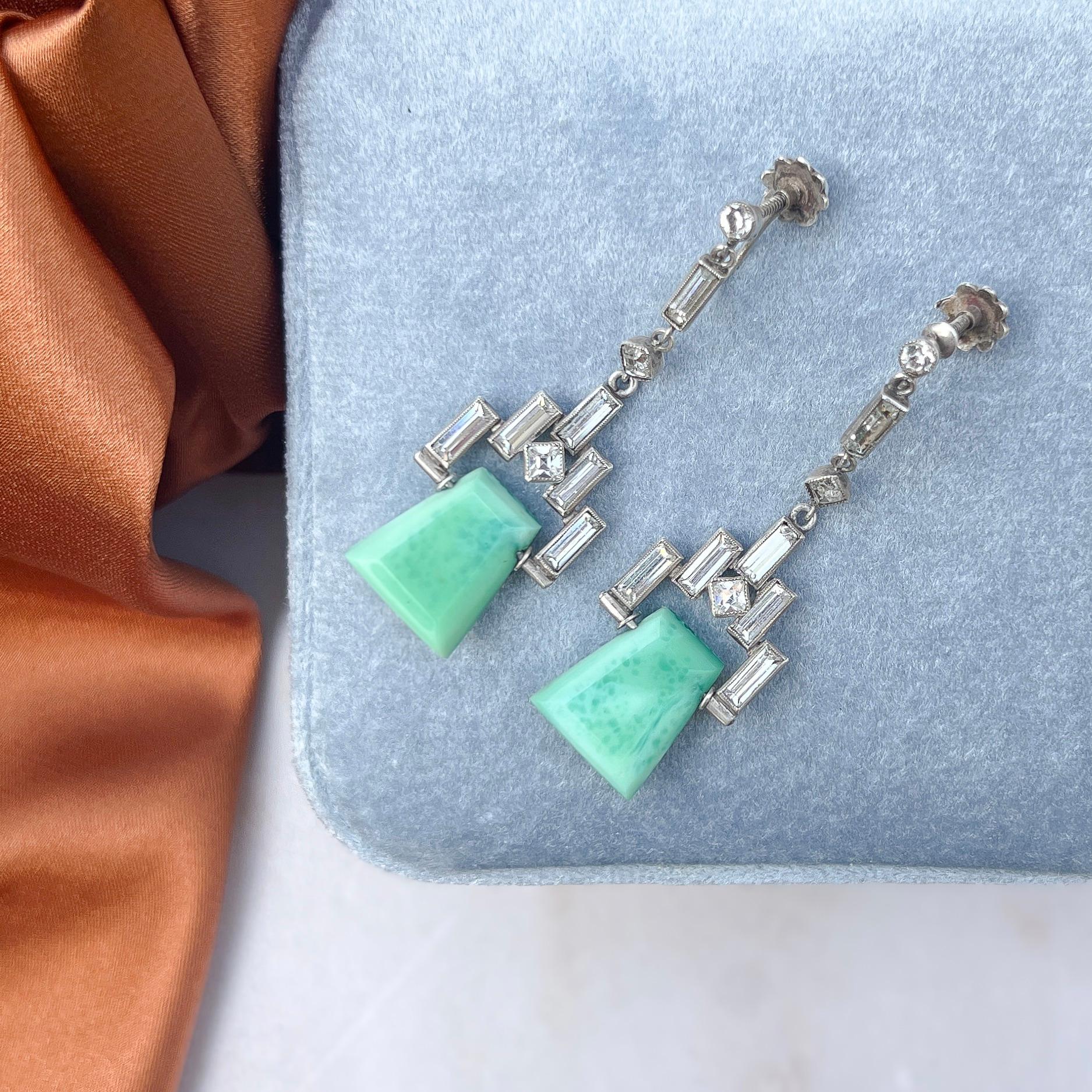These elegant earrings, featuring green glass trapezoid drops, date from the 1920s. 

Condition Report:
Very Good - One of the baguette paste stones has moved slightly within its setting. This is only apparent upon very close inspection with a