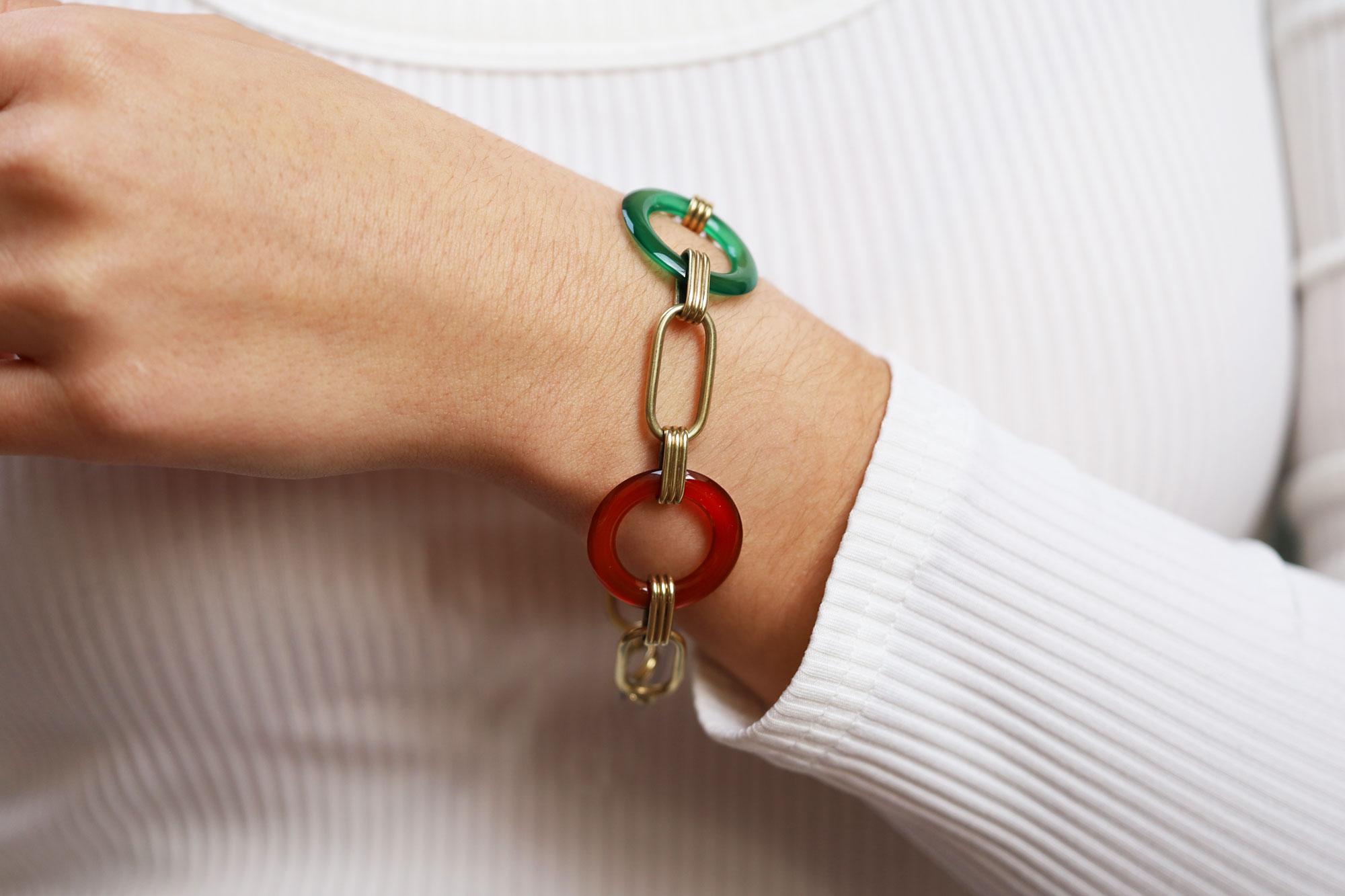 Un bracelet à maillons en pierres précieuses de style Art déco, délicieusement coloré et fantaisiste. Ce spécimen sculptural présente une combinaison intrigante de couleurs vertes et oranges reliées par des stations ovales et des boucles, le tout en