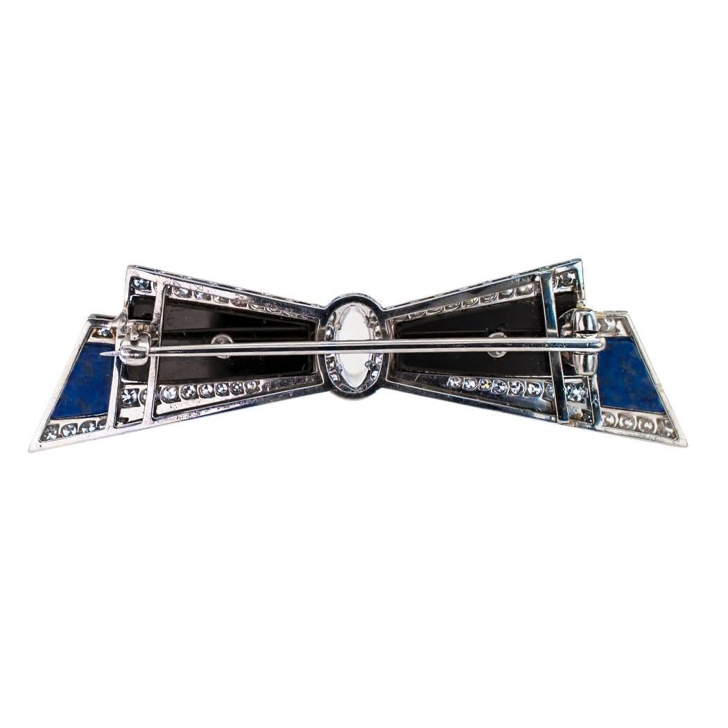 Art Deco 1925 bow brooch diamonds moonstone lapis lazuli onyx and platinum. This most unique Art Deco bow brooch is set with sixty diamonds totaling approximately 1.00 carat, and inlaid with black onyx and lapis lazuli with a navette-shaped