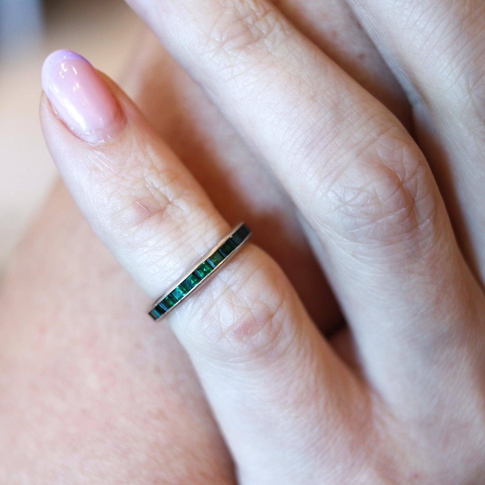 Eternity band with emeralds.

This is a beautiful eternity band ring made during the art deco period, back in the 1930's. The ring is a classic, and has been crafted in solid white gold of 14 karats with high polished finish. It is embellished with