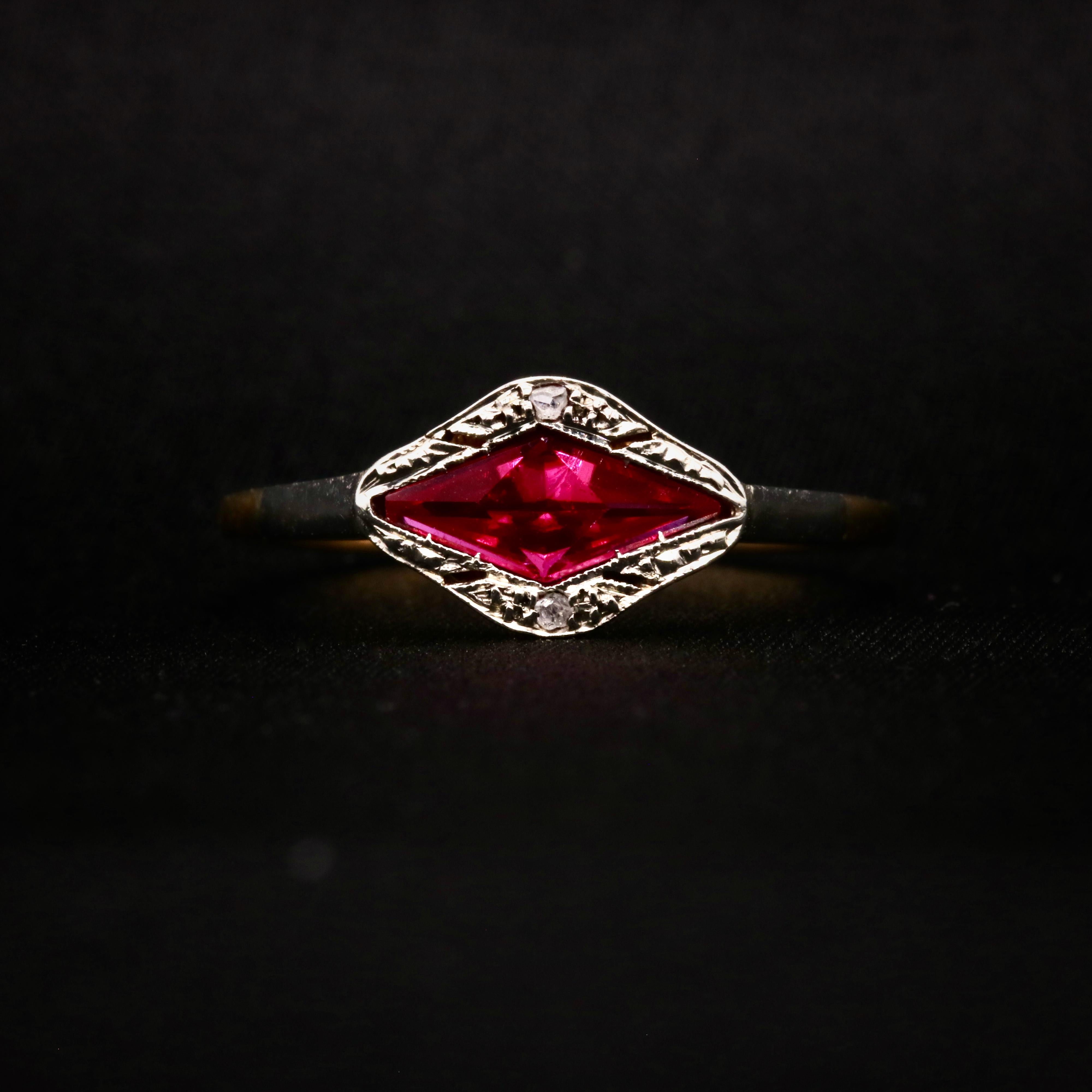 An Art Deco ruby, diamond, platinum, and yellow gold ring, comprising one lozenge shaped ruby, and two rose cut diamonds, in 18 karat white and yellow gold. 

My favourite thing about this Art Deco 18K Gold Ruby and Diamond Ring, is the striking cut