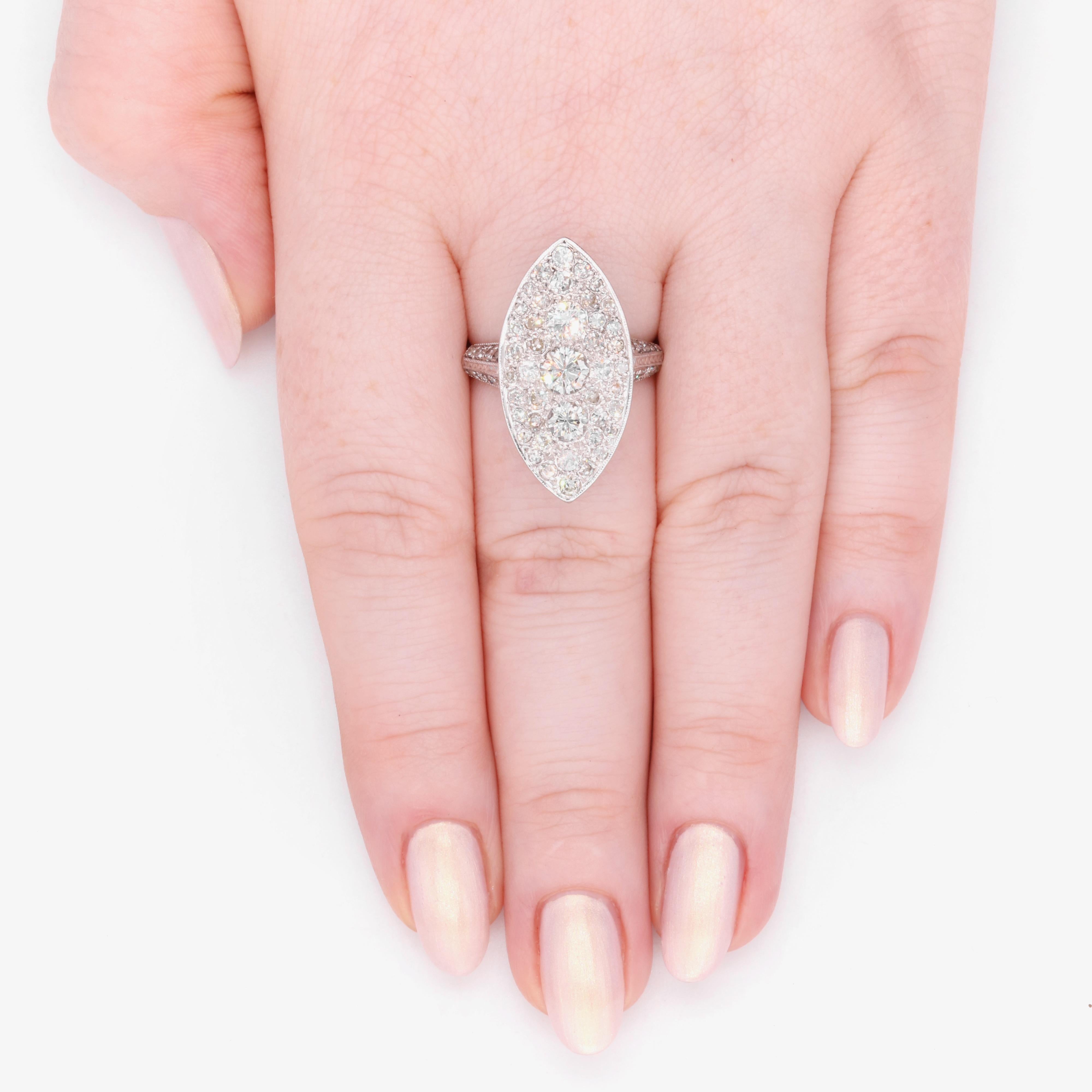 Ein Art-Deco-Ring aus Diamanten und Weißgold, bestehend aus drei großen runden Diamanten im Brillantschliff und sechsundfünfzig kleineren runden Diamanten im Brillantschliff und im Einzelschliff, gefasst in 18 Karat Weißgold, an einem Band aus 18