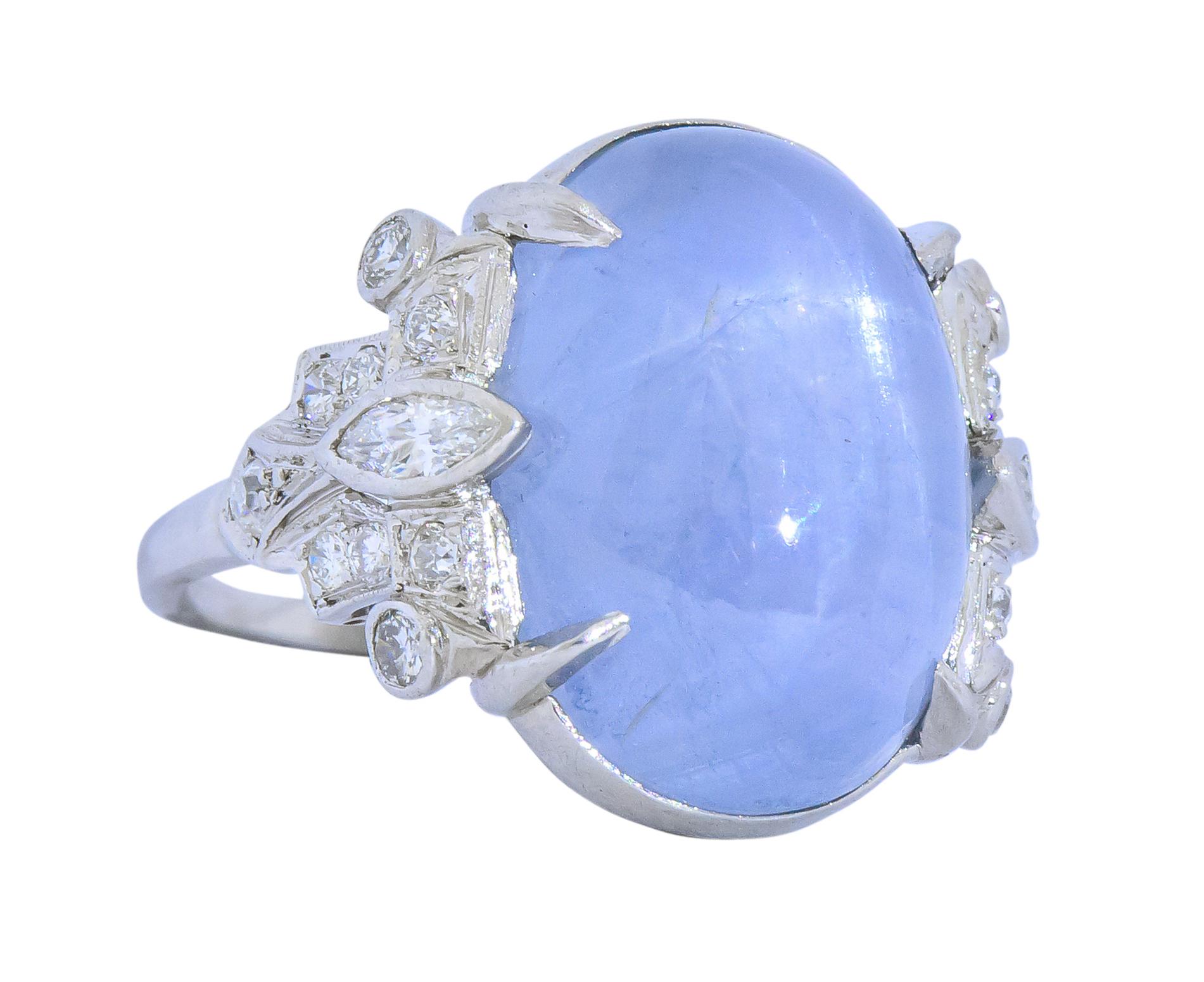Centering a claw set star sapphire cabochon weighing approximately 22.00 carats

Translucent grayish-blue with a strong six rayed star

Flanked by marquise and old European cut diamonds weighing 0.90 carat; eye-clean and white

Tested as