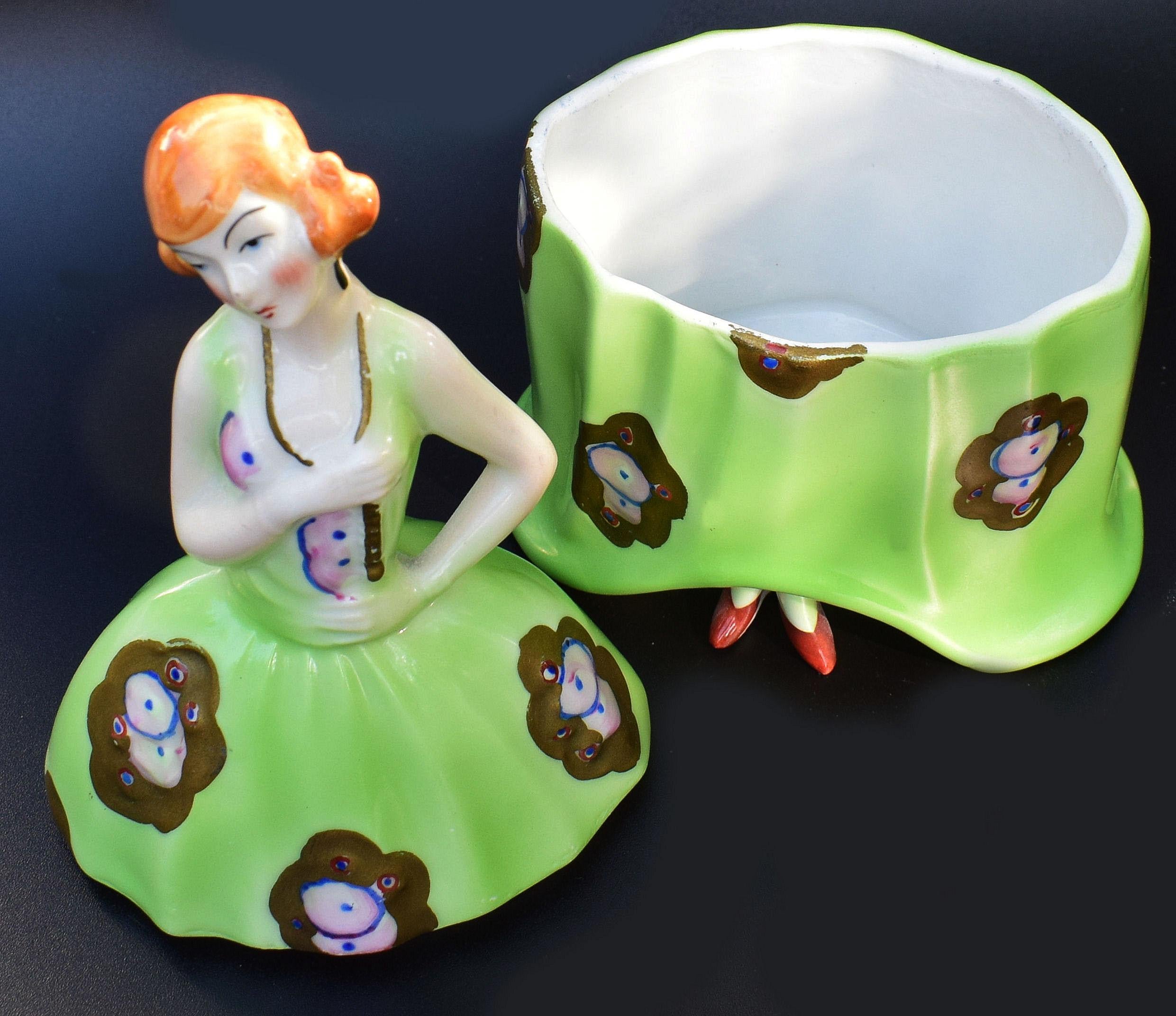 Beautifully styled is this 1930s Art Deco French Bonbonniere. Part of the half doll, powder box, jar family. Typical Art Deco coloring which is as bright and crisp as when first manufactured. The glaze is also free from crazing. Wonderfully styled