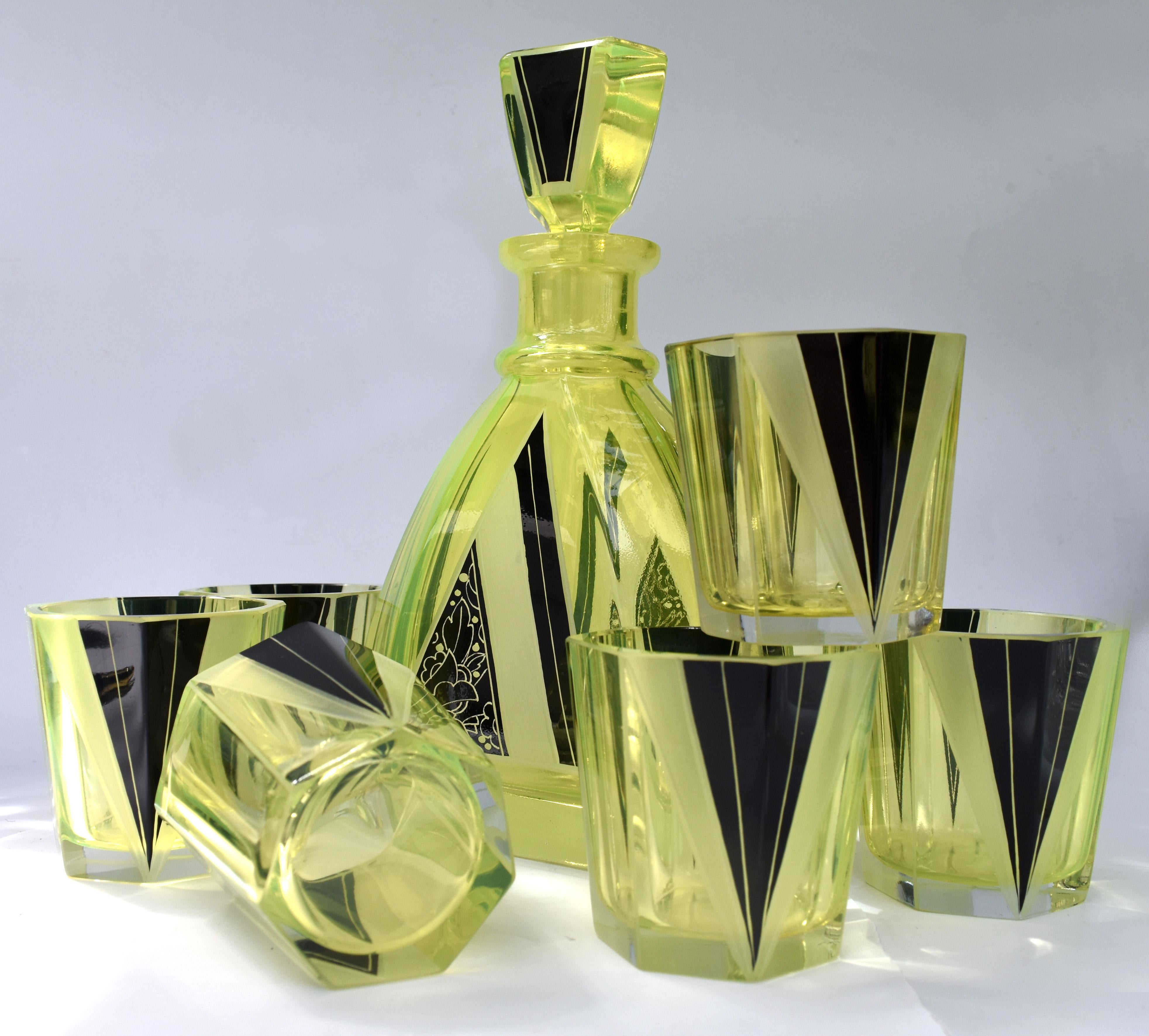 Very stylish and appealing Art Deco decanter set which comes with six matching glasses, and decanter, the whole being heavily enamelled with geometric decoration. The colour is a lemon yellow with black enamelling and etched accents and the