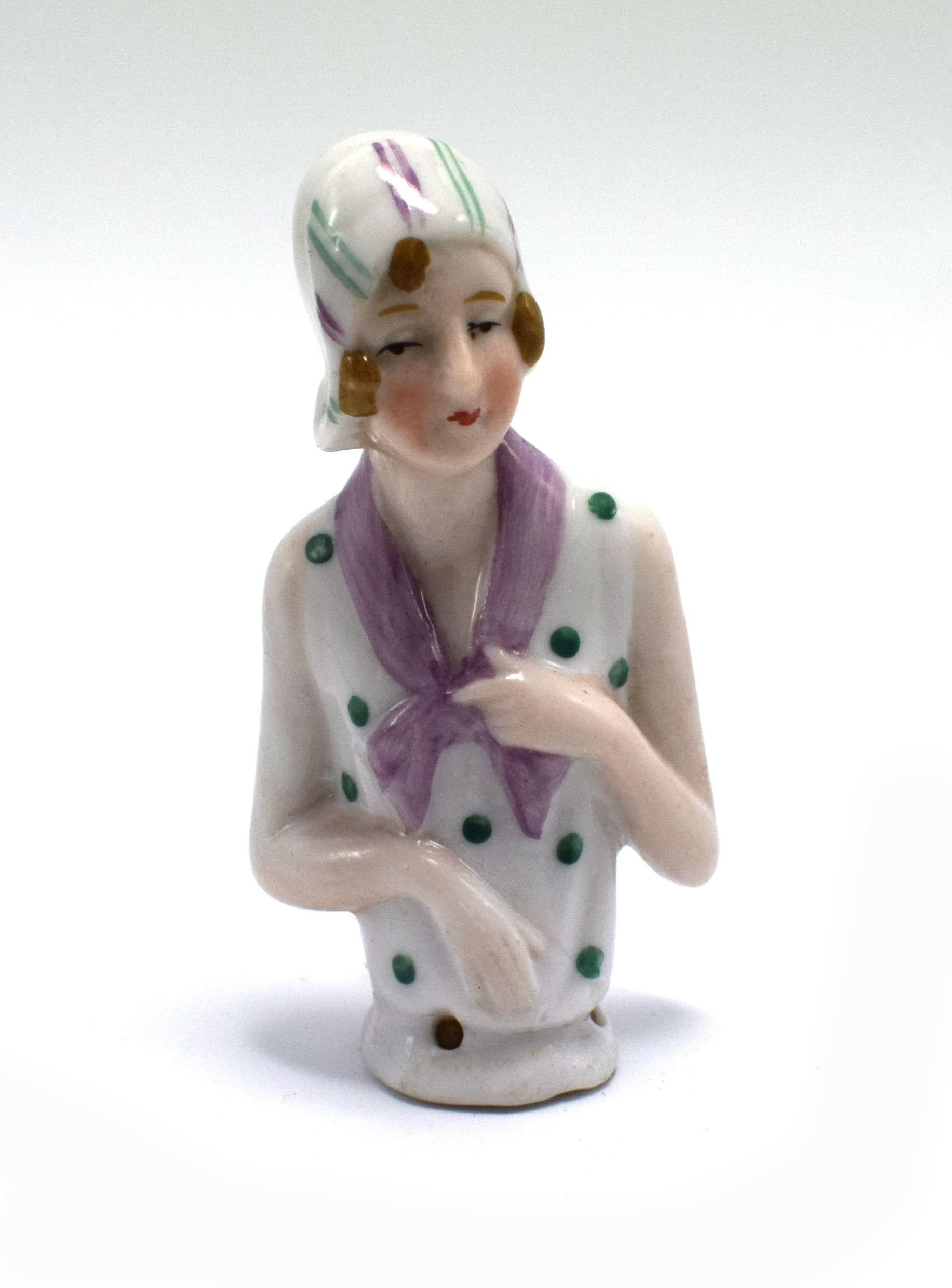 On offer and for your consideration is this charming and totally authentic late 1930s Art Deco German porcelain pin cushion half doll in the form of a pretty flapper girl with a cloche hat and bob hair cut. She's wearing a fashionable of the time
