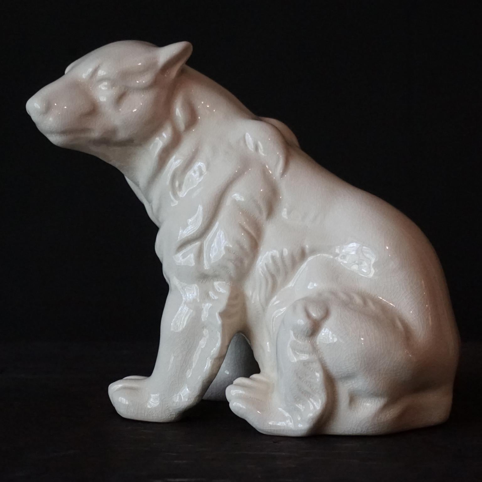 Stunning Art-Deco 1930s French sitting polar bear by L&V Ceram.
Made out of off-white ceramic covered with a shiny crackled glaze.
Stamped with the L and V Ceram logo on the bottom. 
Ceram means ceramic in French.
In mint condition.