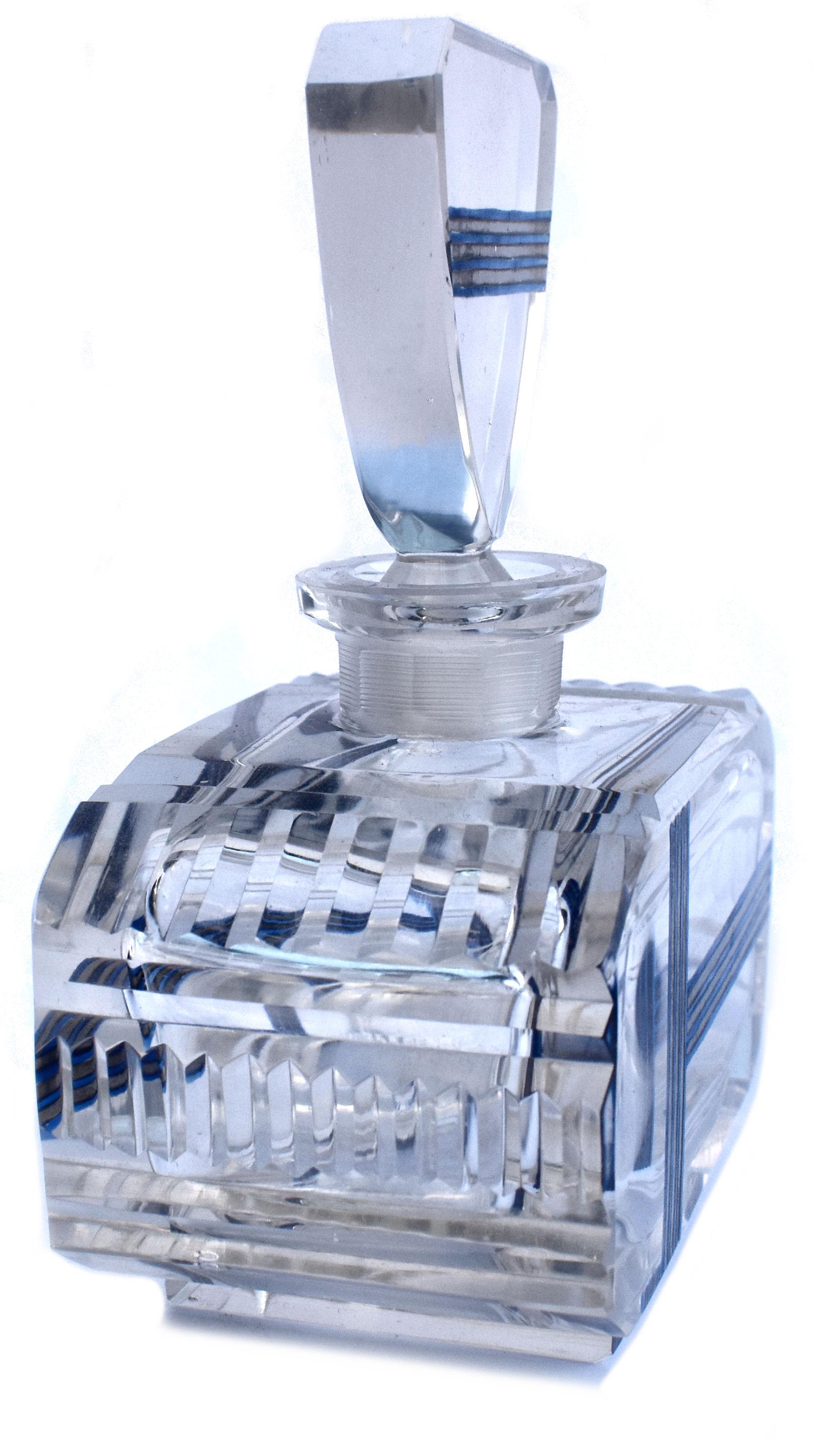 Grand flacon de parfum en verre taillé Art Déco, datant des années 1930 et provenant de France. En verre bleu vif avec un motif géométrique émaillé argenté. Bouchon en verre taillé. Juste un petit résidu de parfum à l'intérieur de la base. Dans