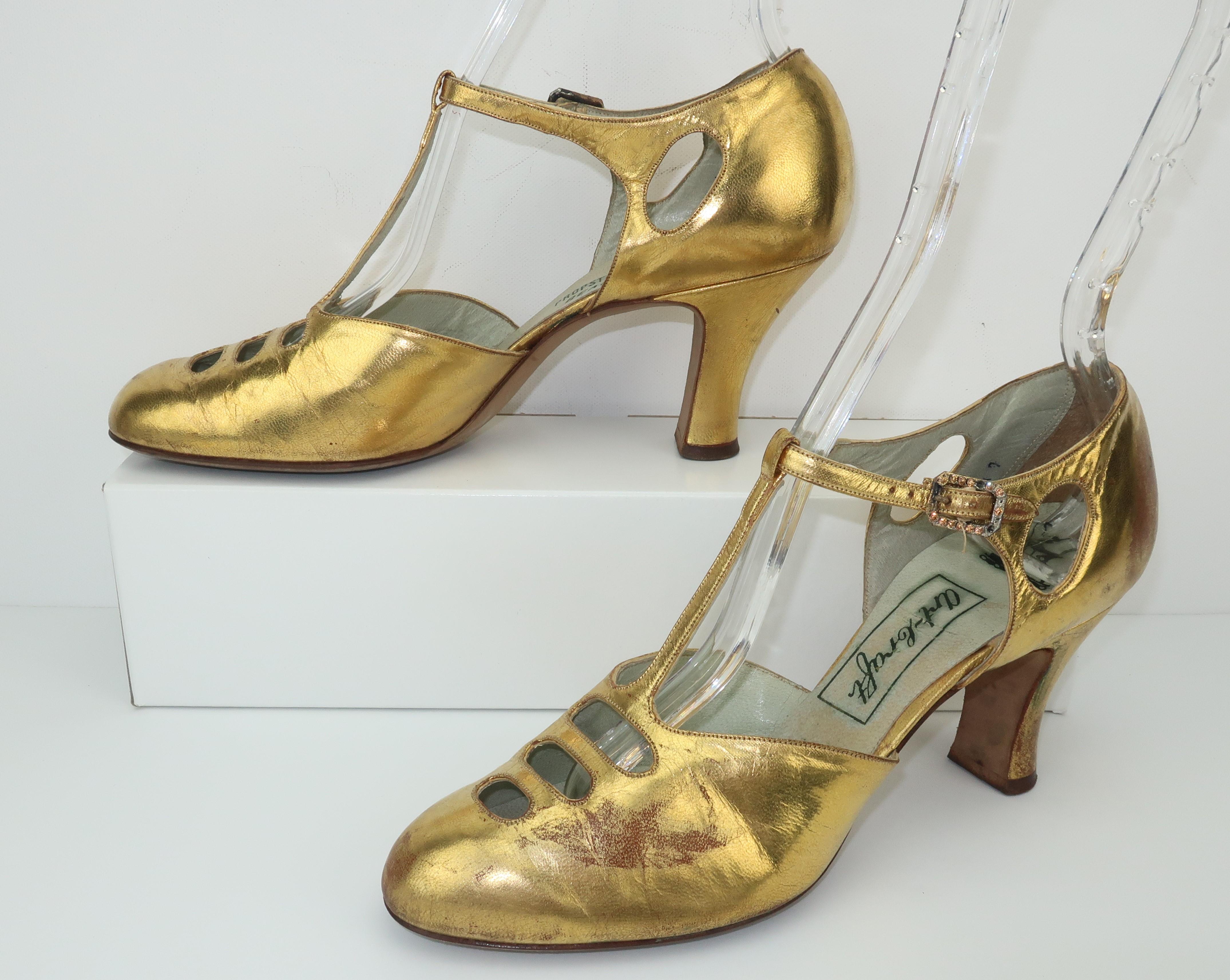Si seulement les chaussures pouvaient parler ... ces ravissantes chaussures de soirée en cuir doré raconteraient une histoire de glamour et de style des années 1930.  Le design classique Art déco de la lanière en T est rehaussé par des découpes