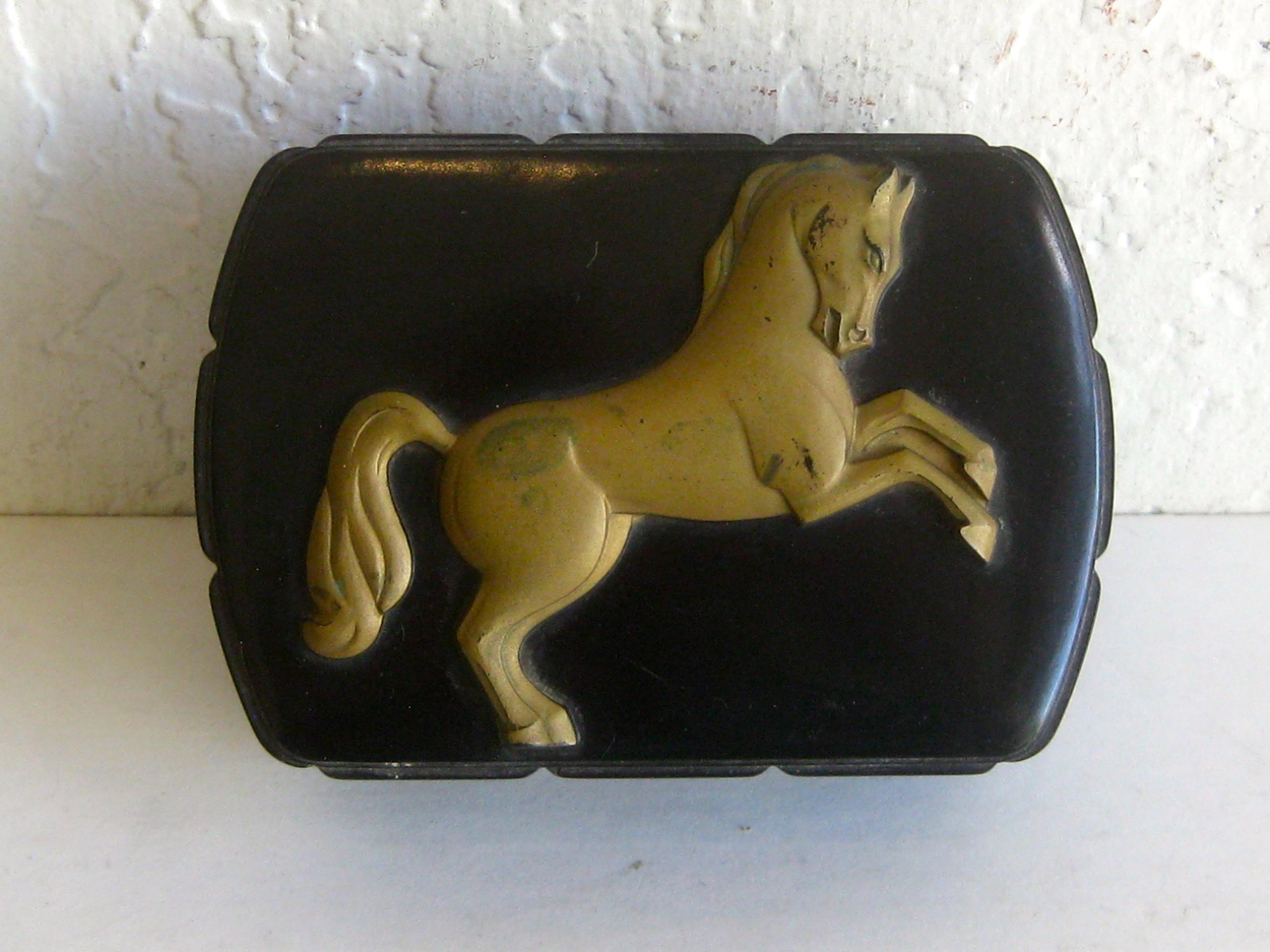 Wonderful original Art Deco black bakelite trinket/stash cigarette box made by Hickok and dates from the 1930s. Has a decorative horse on top and applied gold paint. Marked by the maker on the inside. In nice original condition. Light wear to the