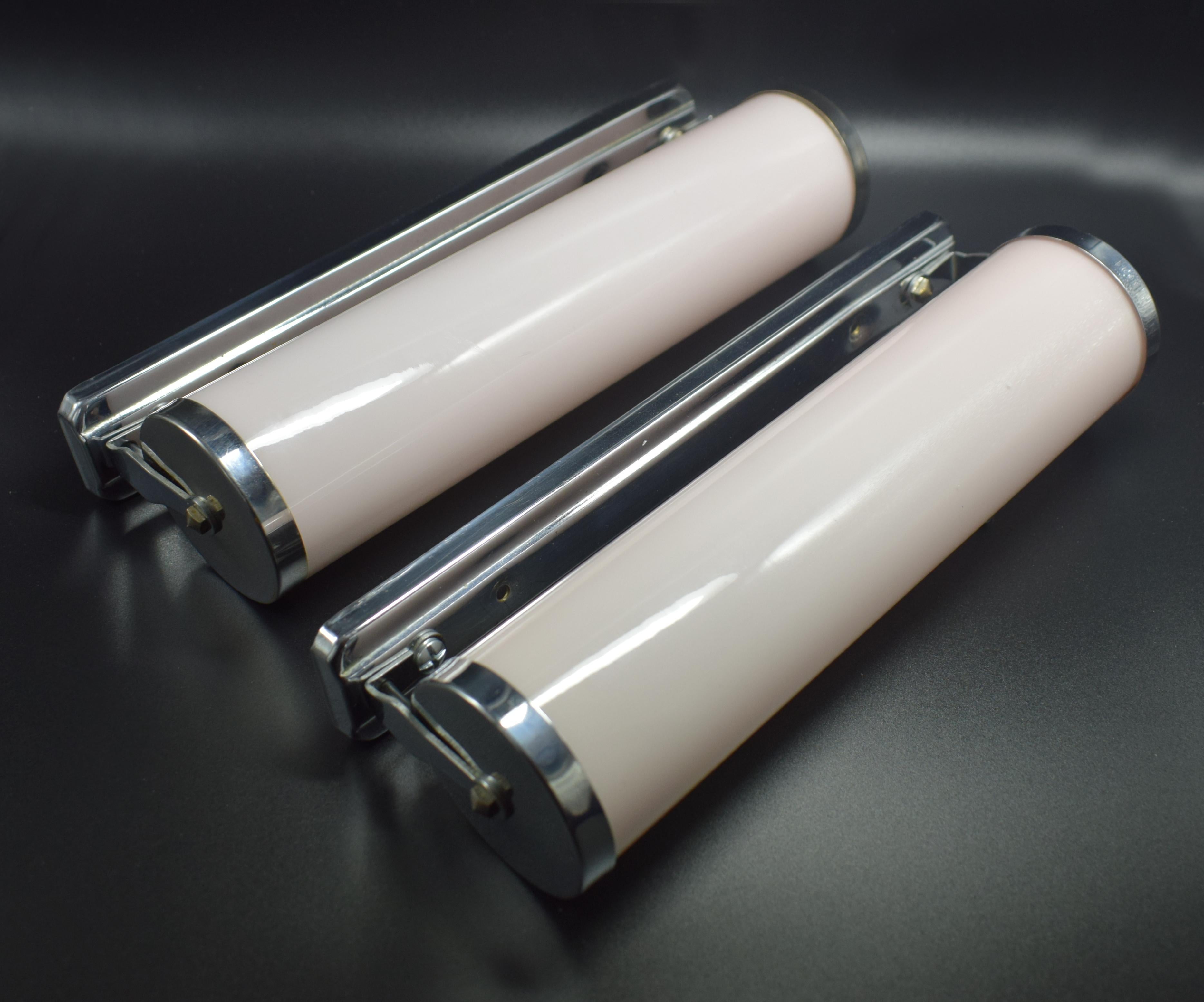For your consideration are these matching pair of 1930s modernist Art Deco wall lights. Ideal for bathrooms, hallways or any where that needs framing with some glamorous lighting. Pale rose pink tubular glass held in chrome frames. Totally authentic
