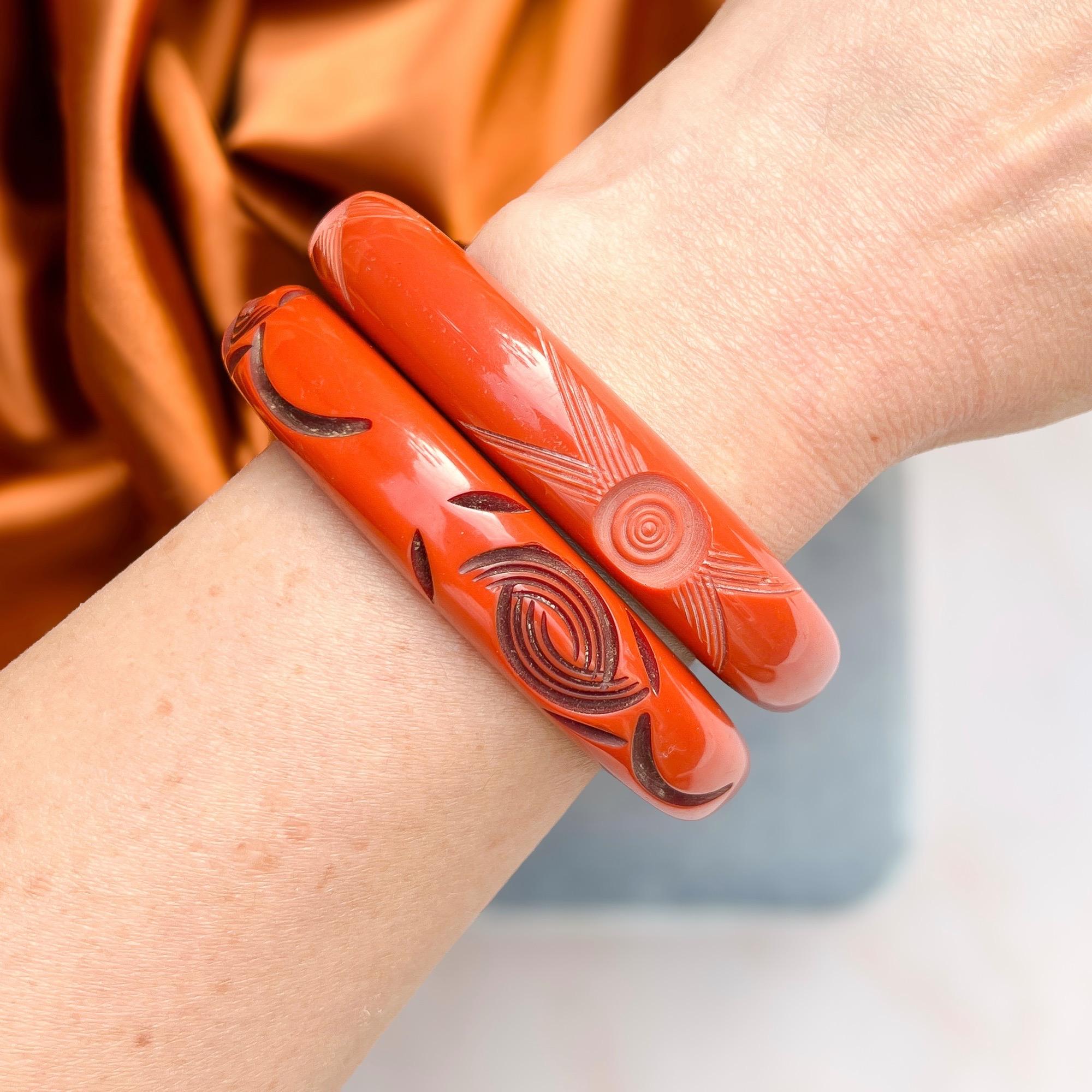 This stylish pair of 1930s bangles exude Art Deco style.

Condition Report:
Excellent

The Details...
These bangles are constructed from an orange or terracotta coloured celluloid. They are each detailed with carved abstract floral designs. The