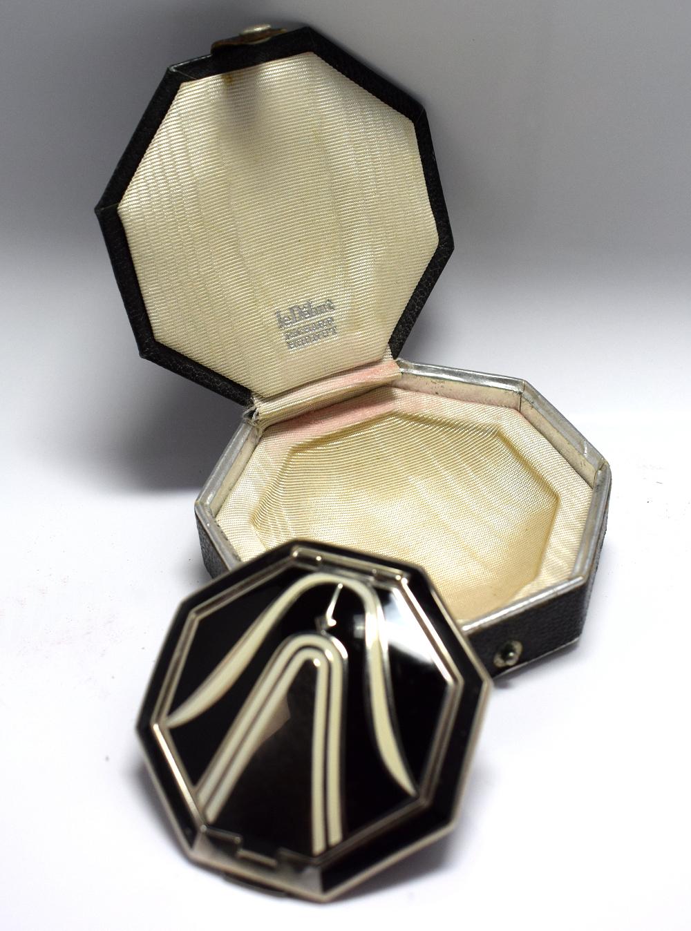 An Art Deco Richard Hudnut Le Debut 'Tulip' compact Of octagonal form, with black and ivory coloured enamelled decoration, fitted in original black leatherette box with paper label. Designed for Richard Hudnuts Deauville Line, the rouge and makeup