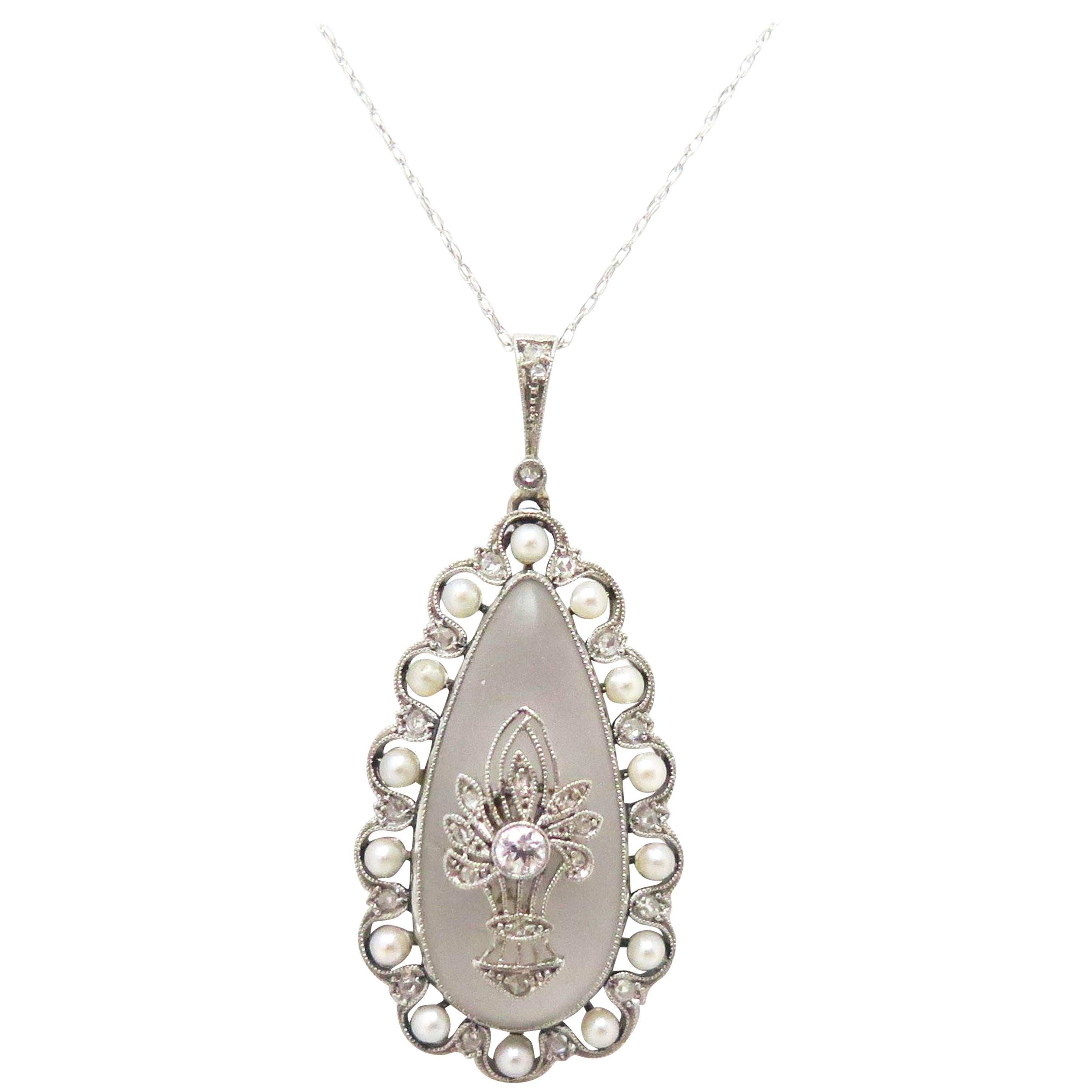 This stunning, Platinum and Diamond pendant with a frosted rock quartz crystal pear shaped plaque has a basket-like motif center. The basket has a bezel set Old European Cut Diamond, and 9 Rose Cut Diamonds inside leaf like settings around it.