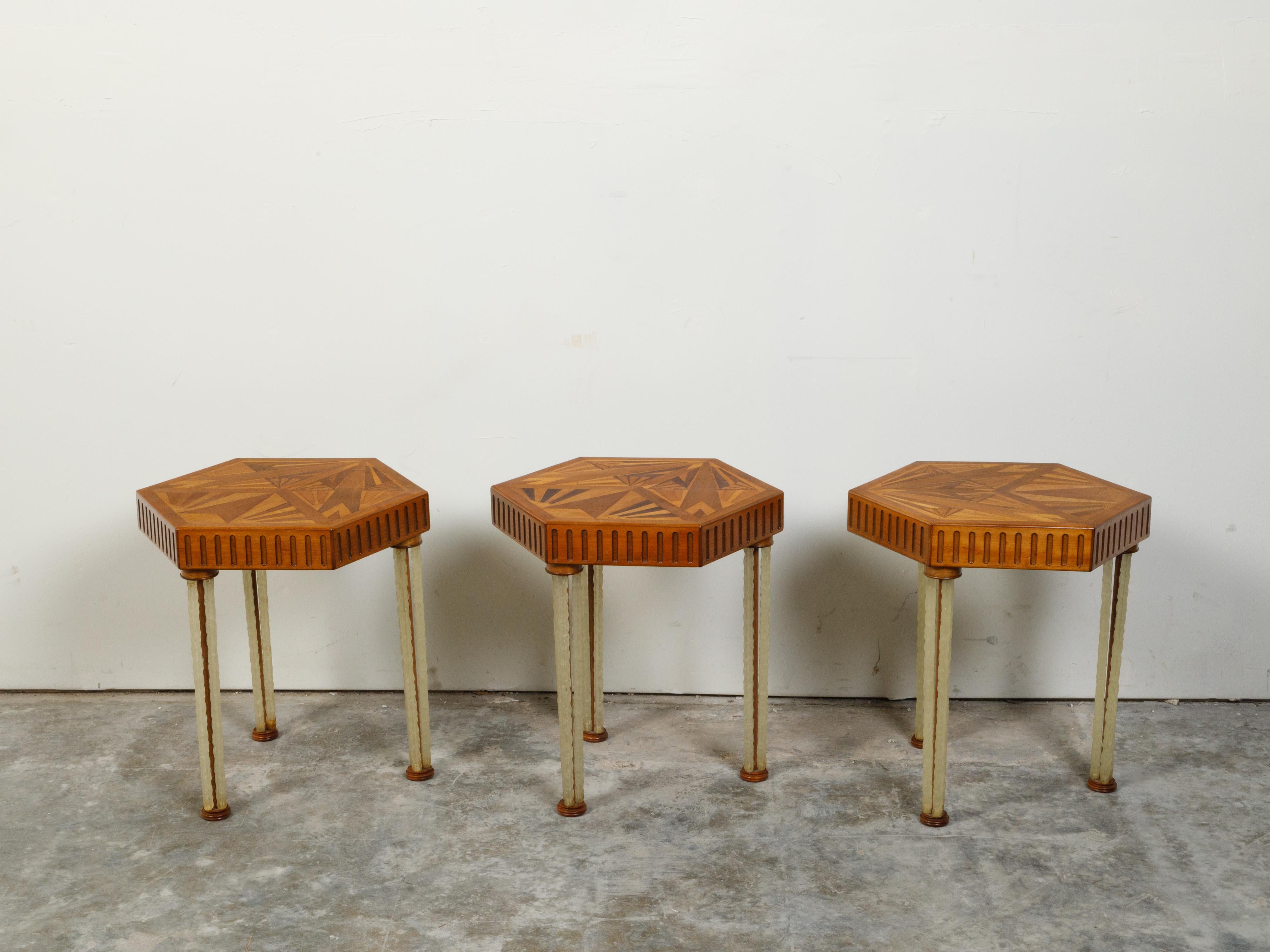 Three Art Deco side tables from the mid 20th century, with hexagonal marquetry tops and lucite legs, priced and sold $3,750 each. Created during the first half of the 20th century, these Art Deco side tables capture our attention with their