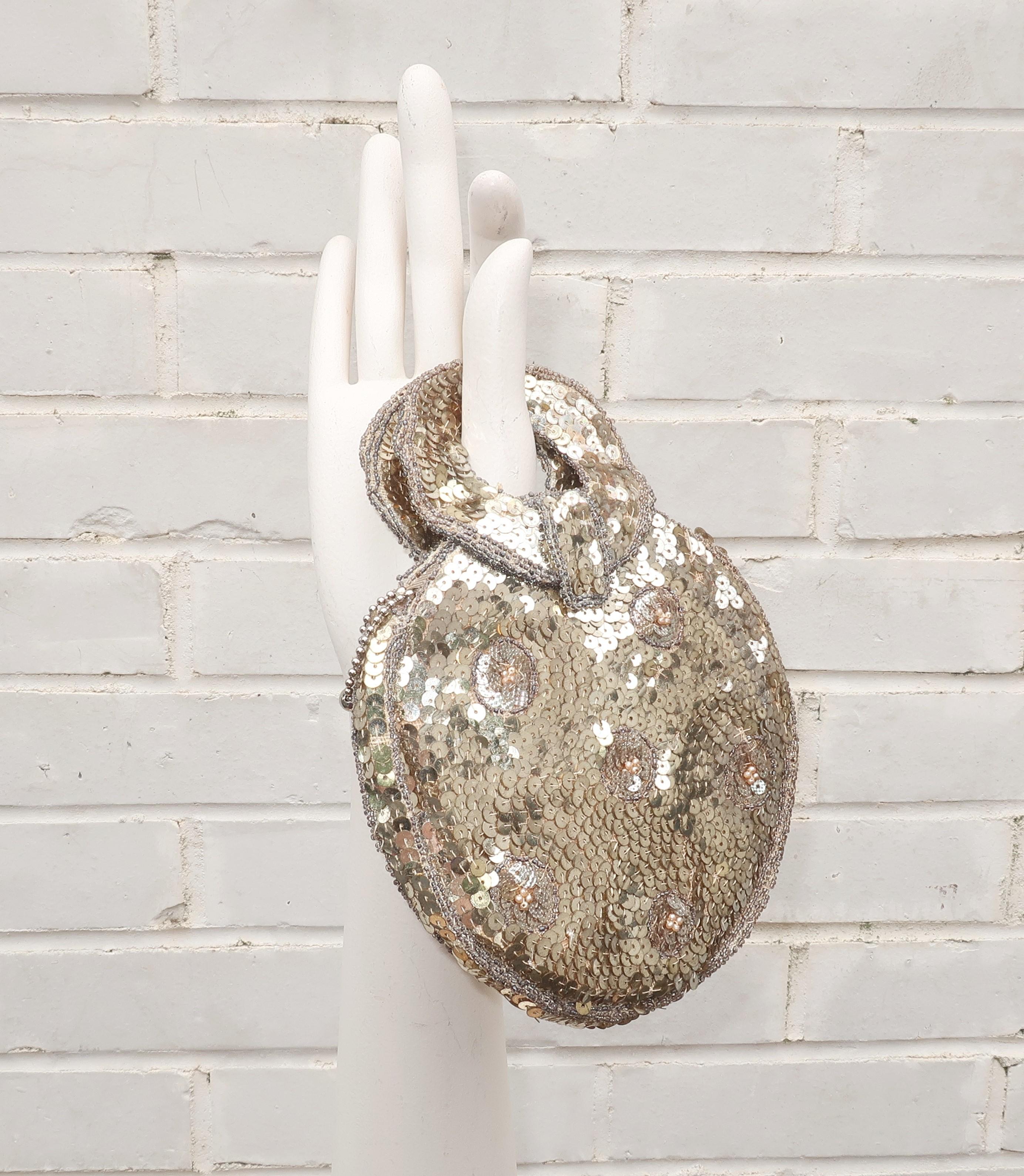 A Czechoslovakian 1930's era silver sequin and beaded petite handbag with a glamorous Art Deco aesthetic.  The unusual round silhouette with ring handles seems to be a style before its time with a space age look that could be equally at home in the