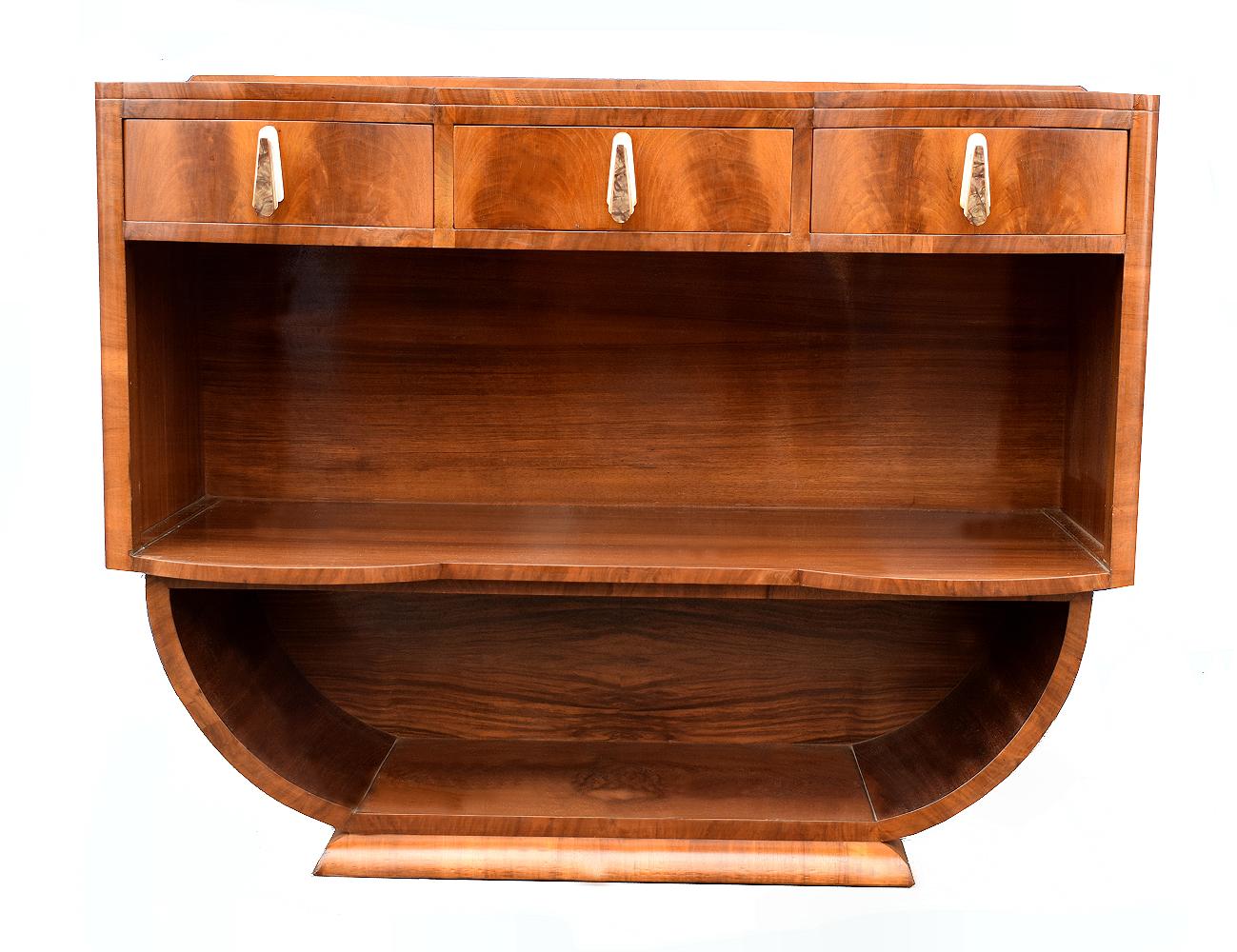 Very stylish and original 1930s Art Deco open sideboard that originates from the UK. An Iconic Art Deco shape which not only looks impressive but is functional too providing great storage and display. Wonderfully figured walnut veneered top which