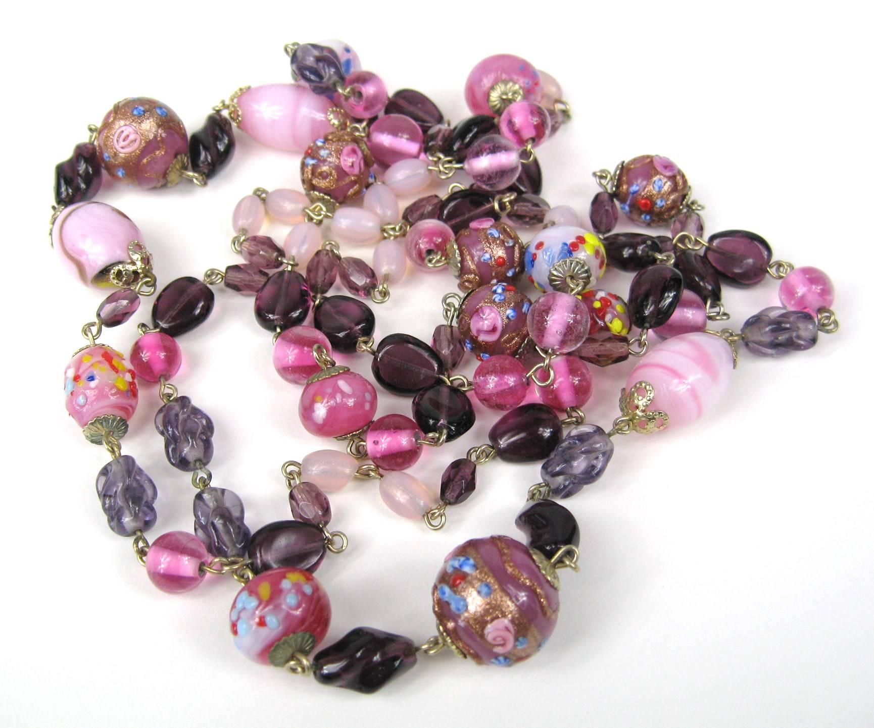 Stunning range of beads on this 1930s necklace *Pink with gold flecked wedding cake beads *Lampwork Beads *Purples and Pinks. Measuring 52 in long. 
This is out of a massive collection of Hopi, Zuni, Navajo, Southwestern, sterling silver, costume