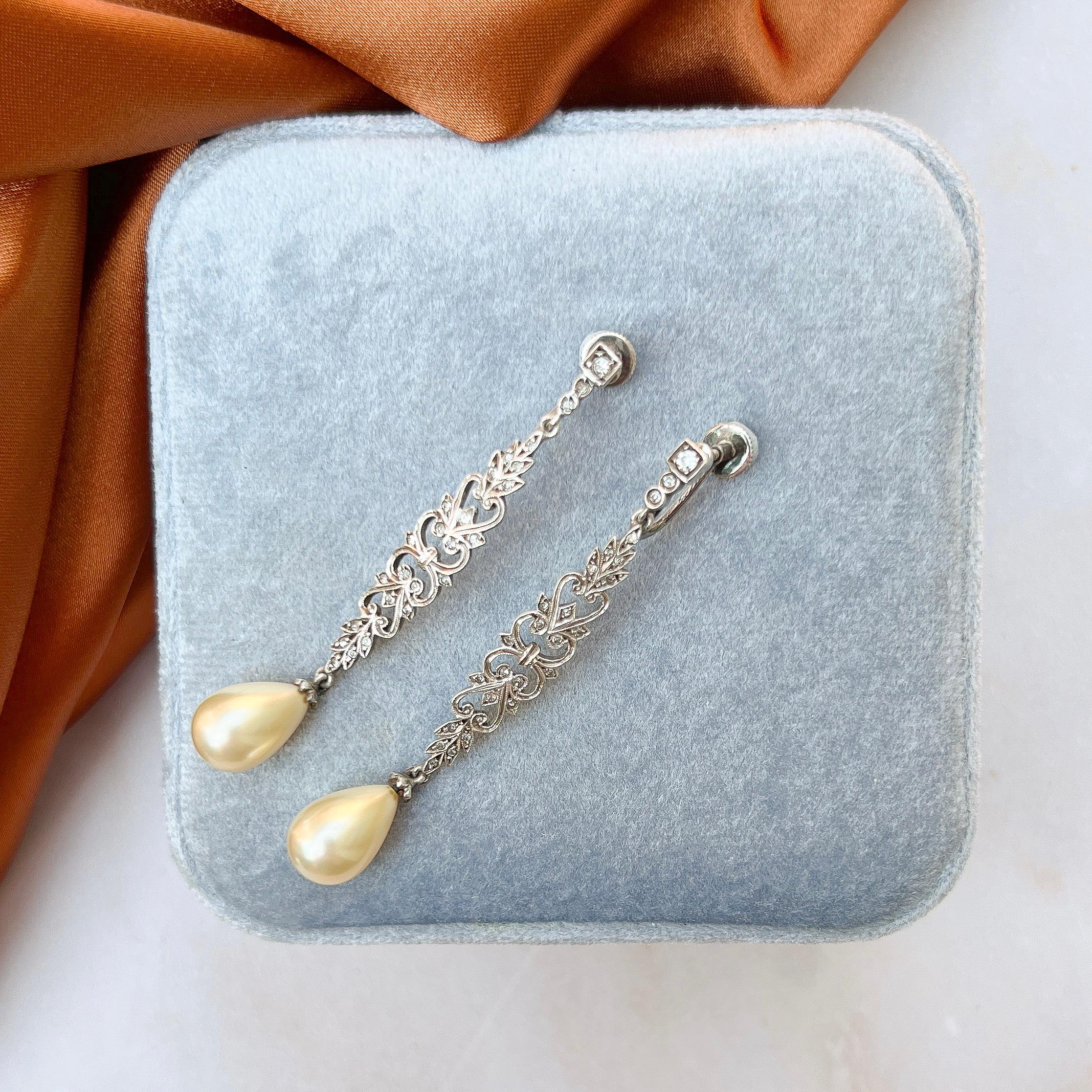 Estos elegantes pendientes presentan bonitas gotas de perlas de imitación y datan de los años 1930-1940.

Informe de estado:
Excelente

Los detalles...
Estos pendientes están fabricados en metal rodiado. Presentan un diseño largo y delicado en forma