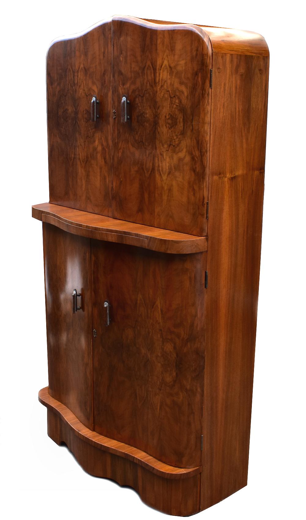 This hugely stylish cocktail cabinet is a fantastic piece of Art Deco furniture, and it's internal features prove to be an incredibly appealing feature. The beautifully presented burr walnut veneers have a superb pattern of grain, serpentine shaped