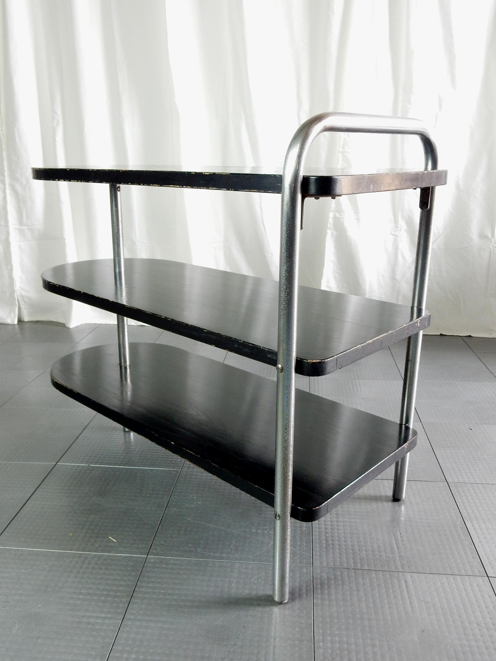 Iron board shape 3-tier end table designed by Wolfgang Hoffmann.
Ebonized wood with nickel plated bent steel tube legs.
Howell label on bottom. Not restored, completely original without repairs or damage.