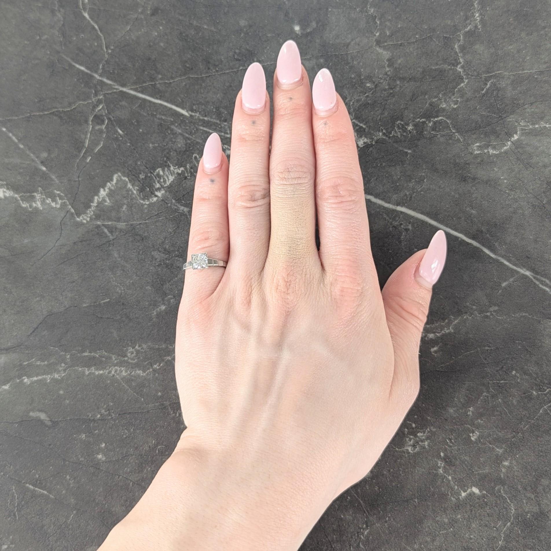 Centering a transitional cut diamond weighing approximately 0.58 carat - H color with VS2 clarity
Bead set in a square form head and flanked by cathedral shoulders
Accented by grooved stepped detail
With milgrain detail
Inscribed with 'H.J to M.B
