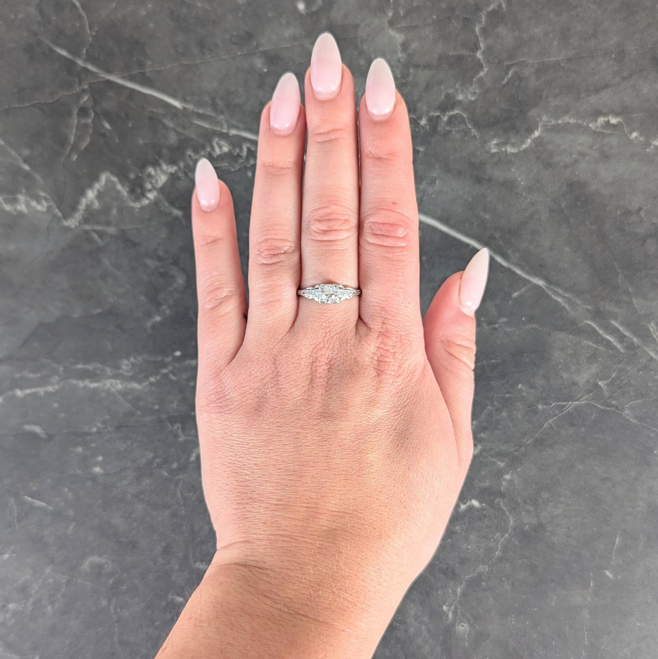 Centering an old European cut diamond weighing approximately 0.58 carat
H color with VS2 clarity - bead set in a square form basket
With a pierced swooping profile with grooved details
Flanked by pierced and stepped shoulders
Bead set with graduated