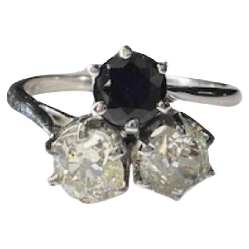 Questo elegante anello Art Deco del 1935 presenta un design straordinario realizzato in oro 18 carati. L'anello presenta un diamante taglio vecchio con un peso totale di 1,22 carati, completato da uno zaffiro australiano taglio brillante del peso di