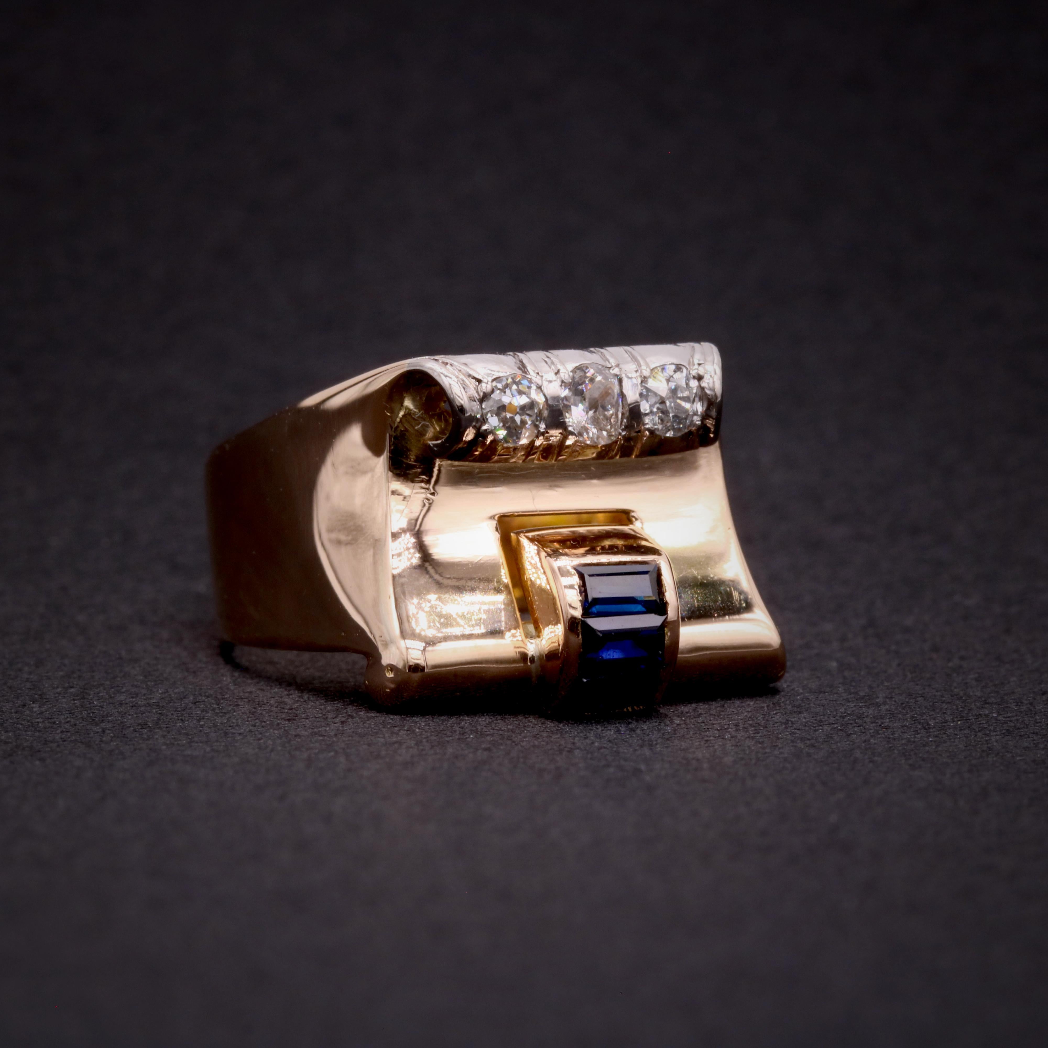Ein Art-Deco-Ring aus Saphiren, Diamanten, Platin und Gelbgold, besetzt mit drei Saphiren im Baguetteschliff und drei Diamanten im Altminenschliff. Die Diamanten sind in Platin gefasst, die Saphire in 18 Karat Gelbgold, an einem Band aus 18 Karat
