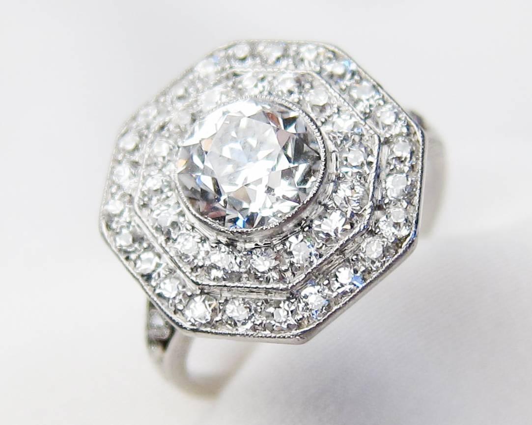 Circa 1930. This fantastic low profile ring celebrates both the beauty of diamonds and the artistry of diamond cutters. The central old European-cut diamond weighs 1.32 carats, with a VVS2 clarity and E color - and is accented with a double tier of