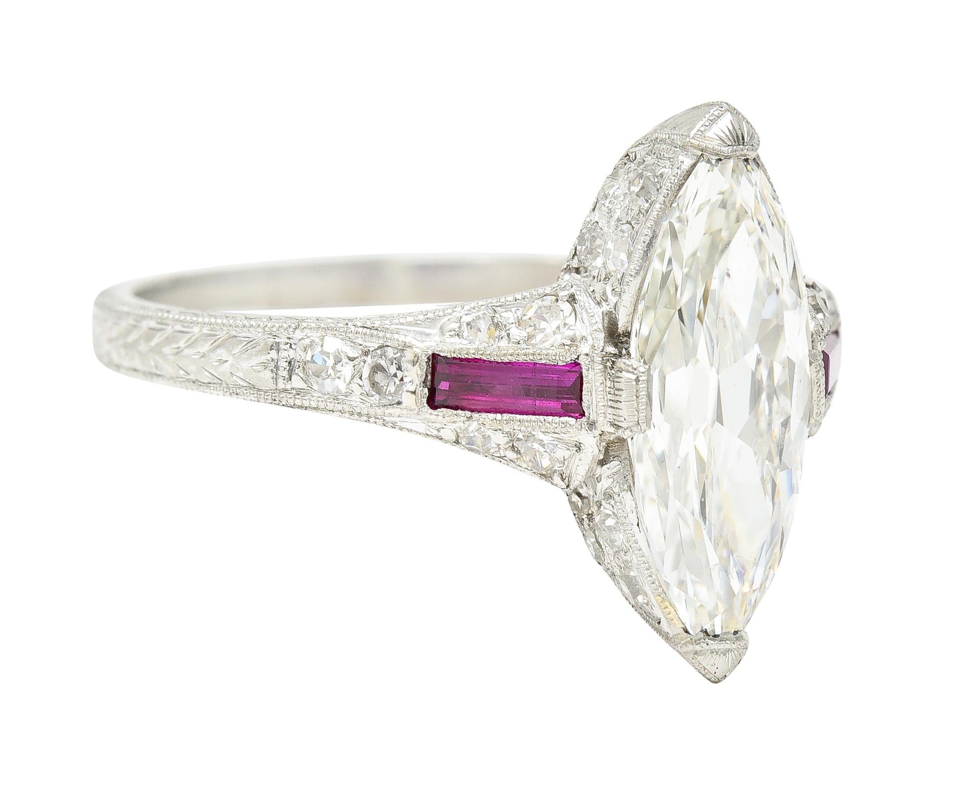 Centering a marquise cut diamond weighing approximately 1.68 carats total - K color with SI1 clarity. Set with engraved tab like prongs and flanked by cathedral shoulders with baguette cut synthetic rubies. Weighing approximately 0.18 carat total -