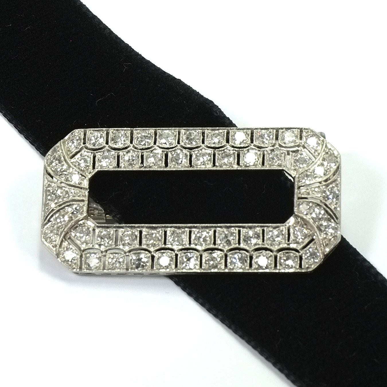 Art Deco 2 Carat Diamond Platinum Buckle Brooch, circa 1920

Decorative platinum brooch in the shape of a buckle, decorated on the sides with stylized palmettes and set with a total of 2 ct sparkling diamonds. Rear needle with plug
