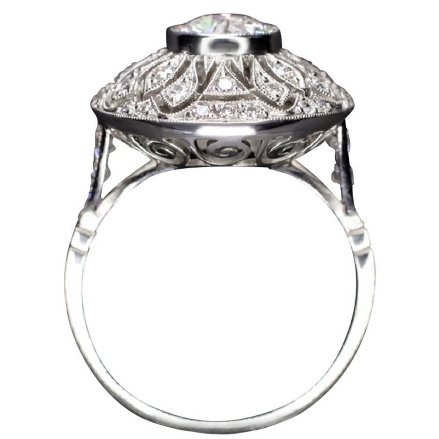 This incredibly detailed engagement ring features a phenomenally brilliant 1.04ct old European cut diamond center complemented by a richly detailed diamond encrusted platinum setting. Fiery, beautifully white, and 100% eye clean, the G-H SI1 diamond