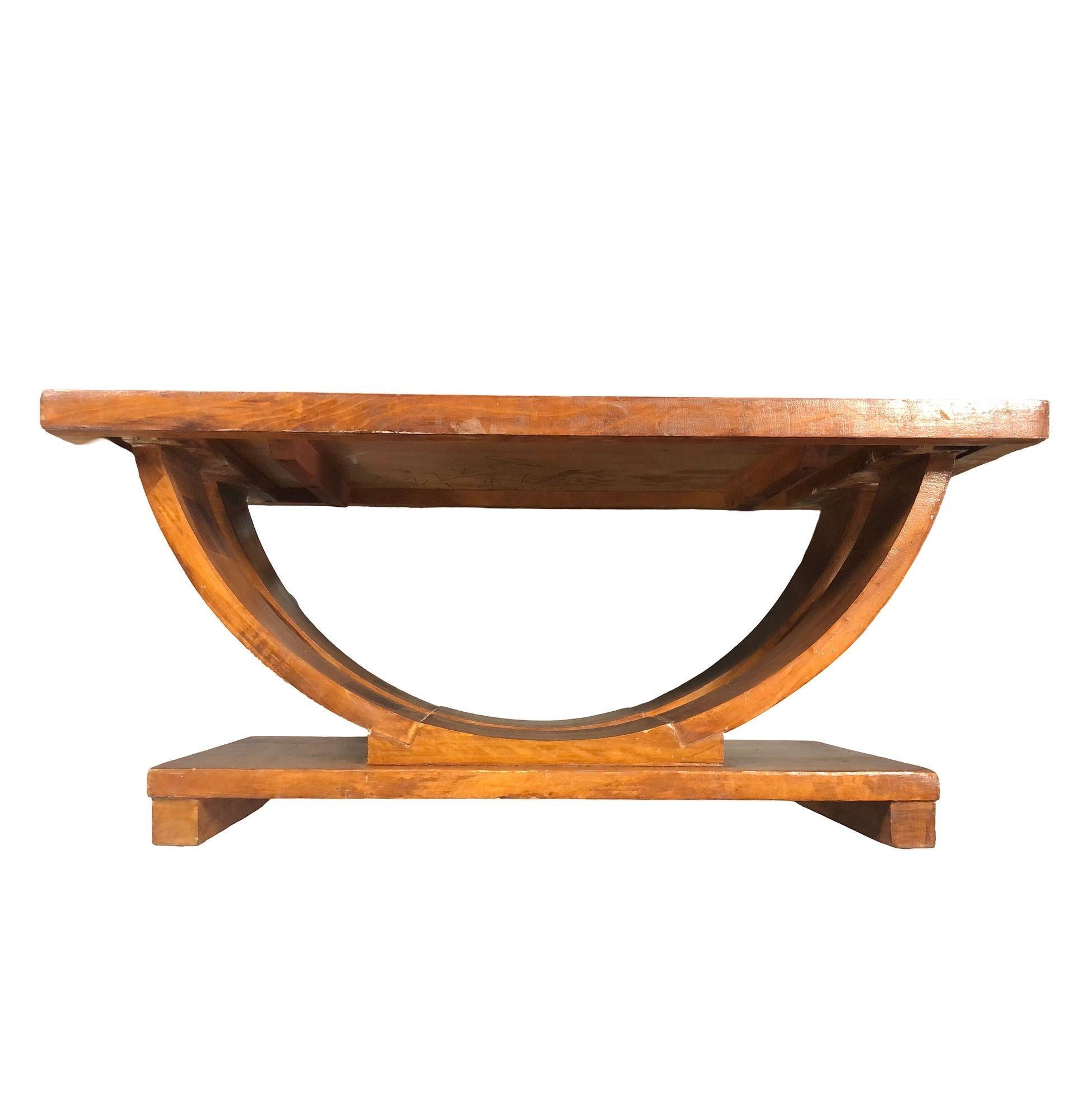 The Art Deco Streamline mahogany coffee/cocktail table by Gilbert Rohde for Brown Saltman. The table showcases a striking round arched silhouette on a square geometric base bringing together elegant Modern curves and an exquisite form. The table is