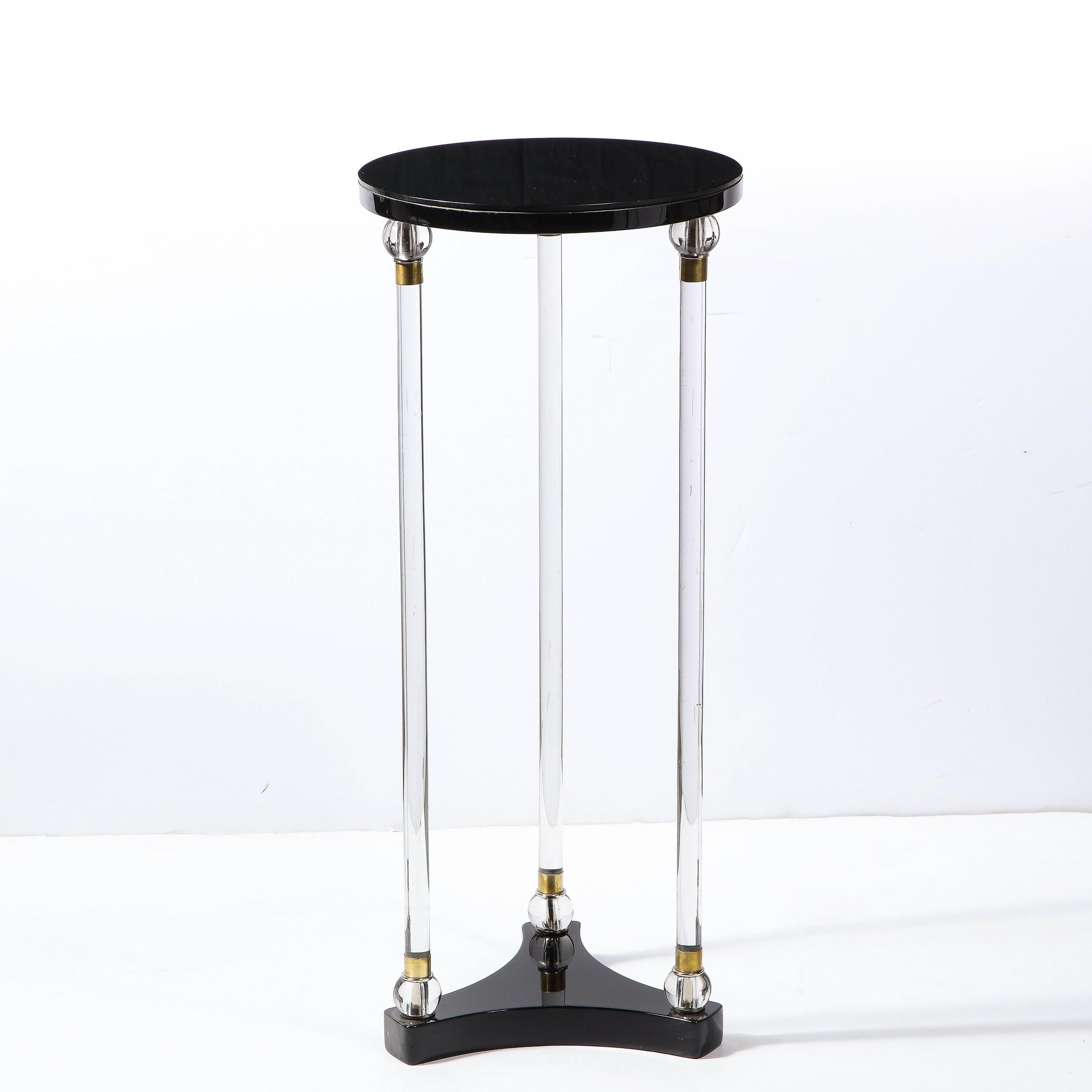 This elegant Art Deco pedestal was realized in the United States circa 1940. It features a black lacquer streamlined three point amorphic base from which three translucent cylindrical glass supports rise, capped on each with spherical embellishments