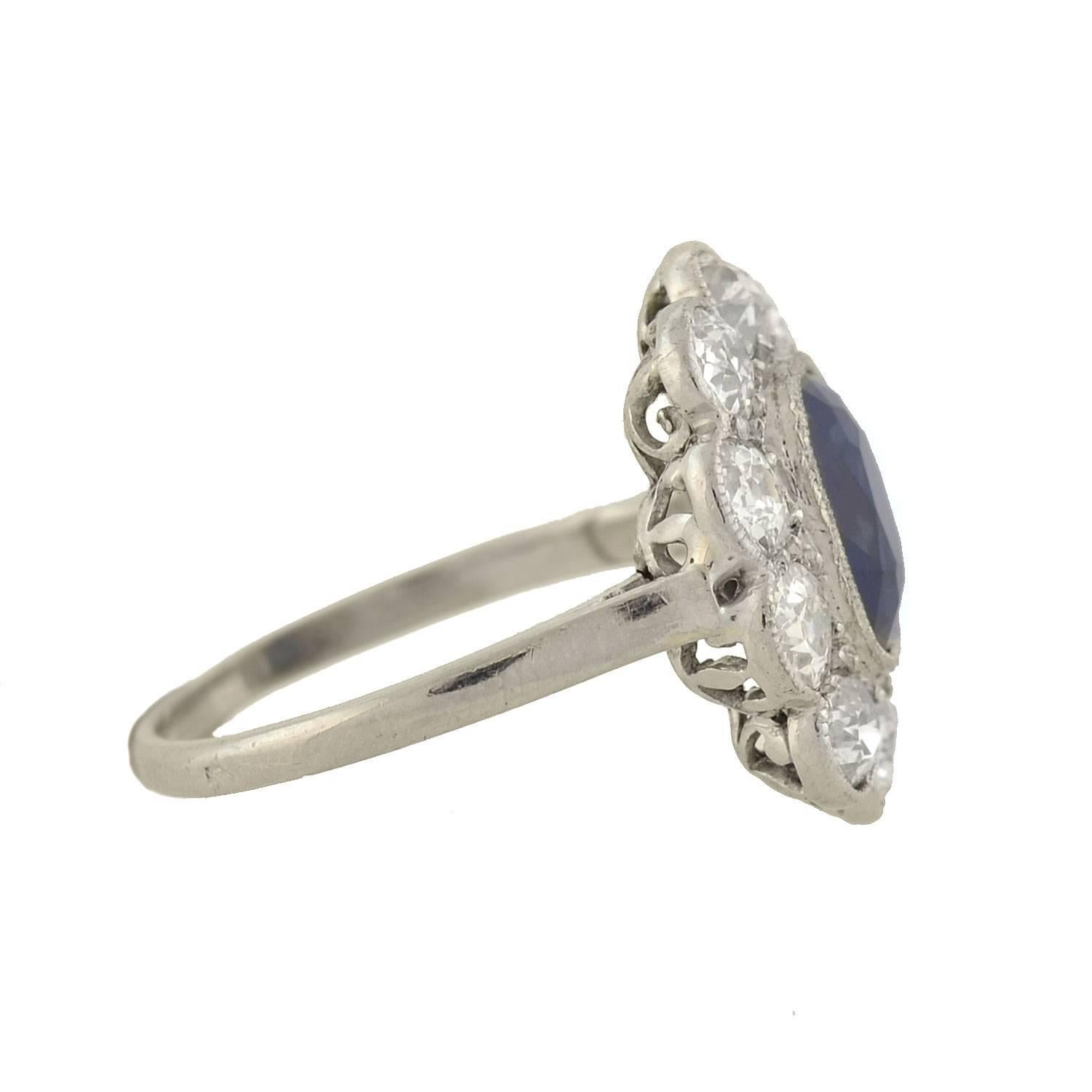 An absolutely gorgeous sapphire and diamond ring from the Art Deco (ca1920) era! This beautiful piece is crafted in platinum and features a 2.00ct sapphire at the center of a diamond encrusted frame. Encircling the sapphire is a scalloped milgrained