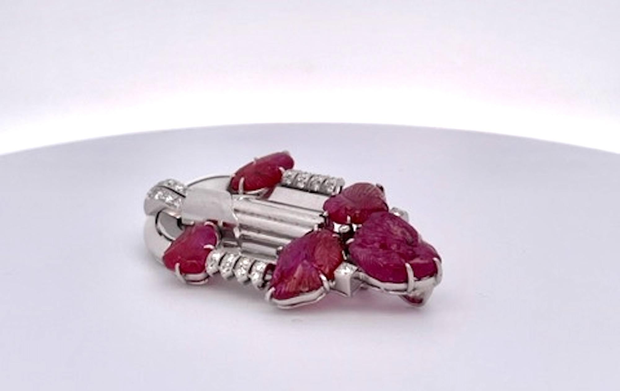 This gorgeous Art Deco brooch is circa 1930 and is set with approximately 20 carats of carved rubies in gold and Platinum. The approximately 1.25 carats of diamonds (G-H color, VS-SI clarity) are set in platinum. This brooch is large at over 2