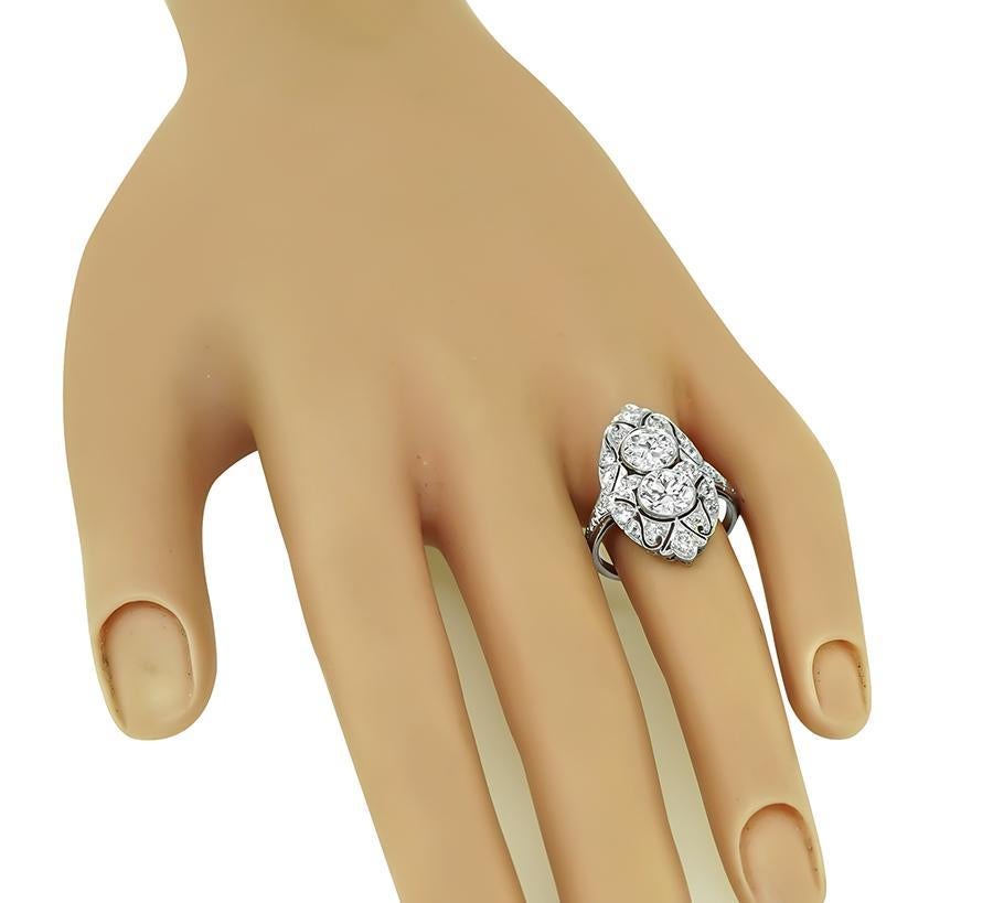 This is a fabulous platinum ring from the Art Deco era. The ring is centered with 2 sparkling old mine cut diamonds that weigh approximately 2.00ct. The color of the diamonds is G-H with VS2 clarity. The diamonds are accentuated by dazzling old mine
