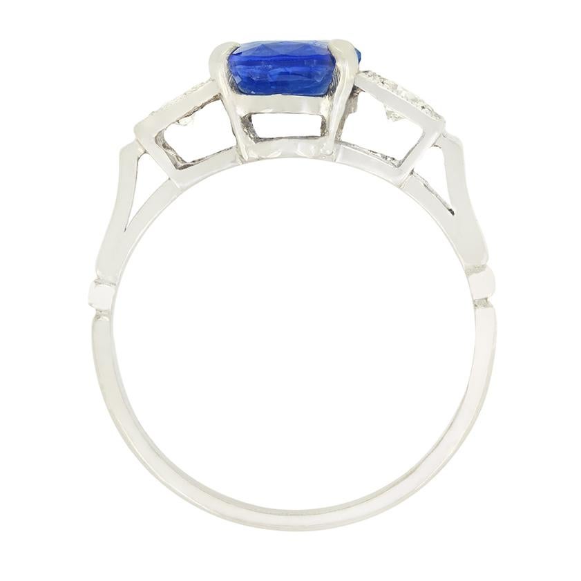 Un bellissimo zaffiro blu è al centro della scena, affiancato da diamanti in questo anello trilogy di epoca Art Déco. Lo zaffiro da 2,00 carati è una pietra completamente naturale, di taglio ovale. La coppia di diamanti che li accompagna è composta