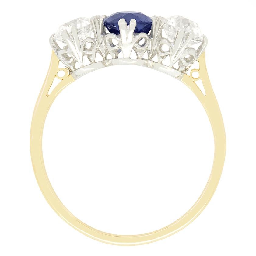 Un intenso zaffiro blu reale si trova tra due diamanti taglio vecchio in questo anello trilogy Art Deco senza tempo. Lo zaffiro naturale non riscaldato è una pietra dal taglio ovale del peso di 2,00 carati. I diamanti laterali sono da 0,50 carati