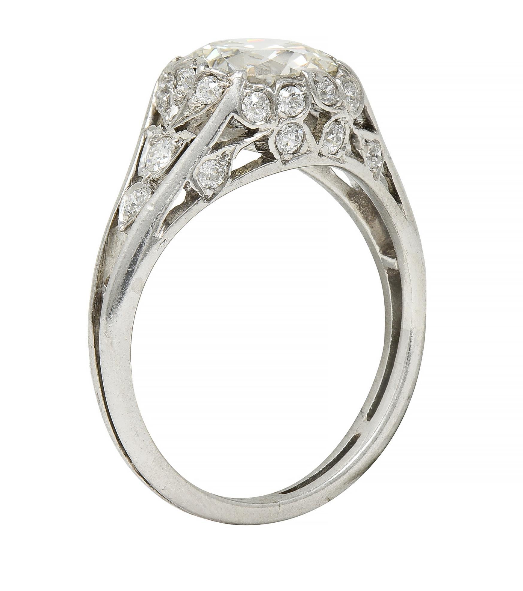 Centering an old European cut diamond weighing approximately 1.50 carats - L color with VS2 clarity
Flush set in foliate motif pierced surround accented by old European and transitional cut diamonds
Bead set and weighing approximately 0.55 cart